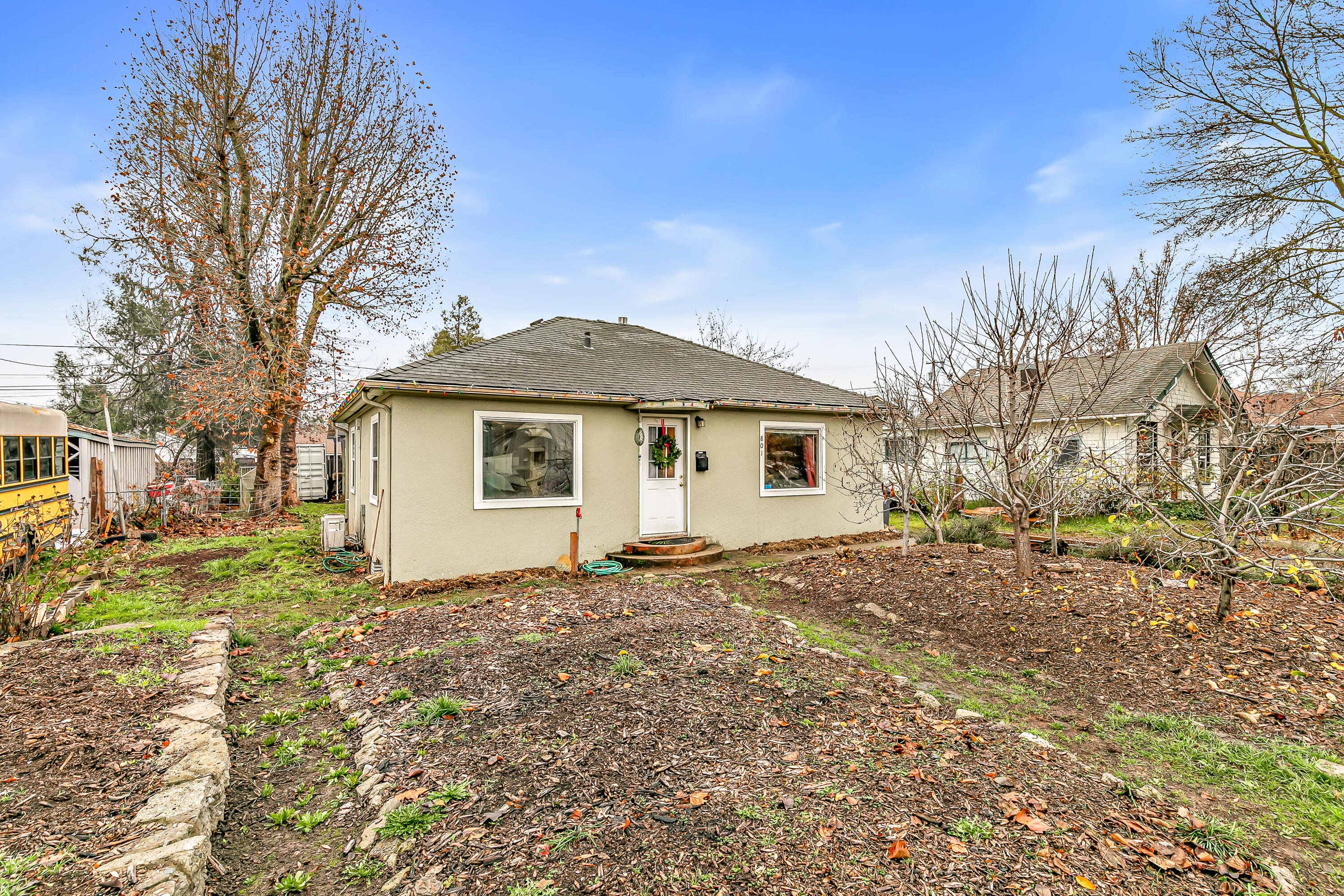 Updated 3BD/1BA home features a fully permitted addition & an impressive list of energy-efficient upgrades, including owned solar, new electrical panel, tankless water heater, mini-split systems throughout, added insulation in the walls & floors, roof and windows replaced in 2015. Original hardwood floors in the cozy living room, which flows into the dining & refreshed kitchen w/brand new LVP flooring, updated countertops, stainless appliances, & open shelving. The bathroom w/ large vanity area that can be closed off separately from the toilet & shower. Off the kitchen is a spacious mudroom with ample storage. A sliding barn door opens to the largest bedroom w/walk-in closet. The backyard has a custom cob bench and pizza oven with fire pit—perfect for enjoying Southern Oregon evenings. Alley access leads to a detached two-car garage with 220 power & shop space, plus a two-car covered carport. Additional parking is available in the front driveway with 30amp RV hookup.