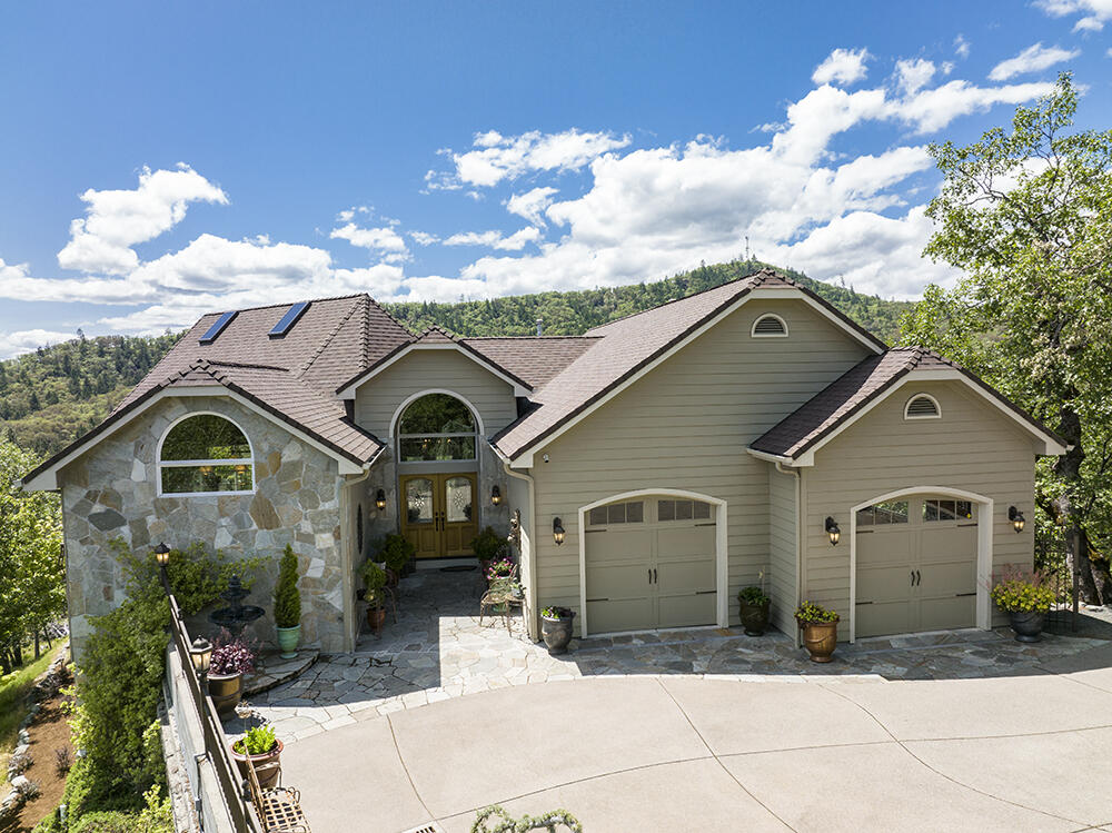 Commanding views from this executive style home located in the desirable Northwest part of town. This 3489 square foot custom built beauty sits on .81 of an acre and the westerly views are beyond stunning!  Lots of large windows flood the home with natural light and there are many small decks and vignettes.  The main level consists of soaring ceilings, fabulous kitchen with live edge granite counters, substantial eating bar, professional cookstove, stainless appliances and lots of storage.  The open floorplan flows thru the dining space, with its Juliet balcony, and into the living room with fireplace, big windows, and another eating/entertaining deck. The primary bedroom is on this level and features a gas fireplace, good sized private deck, and stunning master bath with soaking tub and walk in closet. Downstairs are the other large bedrooms, office, laundry room and more patio spaces. Looking West you see only trees and the twinkling city lights at night. Immaculate inside and out.