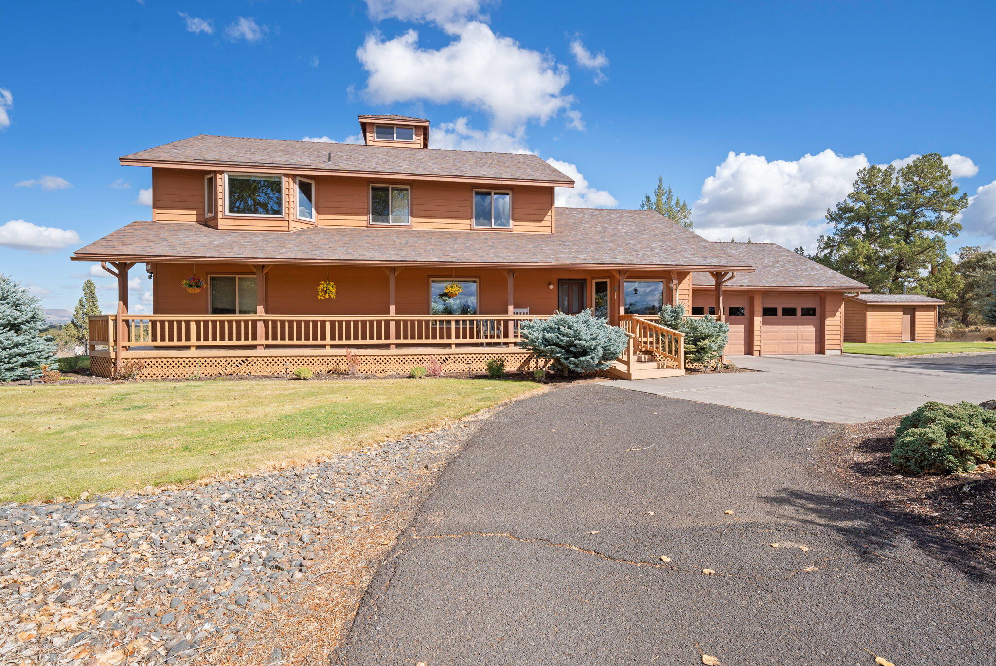 Quintessential farmhouse on over 5 acres in desirable Tetherow Crossing. Set atop a breathtaking valley with sweeping views from the Cascade Mountains to Smith Rock, this well-loved home is ready for your vision. Enjoy idyllic vaulted wood ceilings and a true wraparound covered porch. The main level features two bedrooms, a full and half bath, and multiple areas to entertain. Upstairs, you'll find a bonus room, office/den, and a spacious primary. The suite is complete with sitting area, soaking tub framed by views, walk-in closet, and private balcony with stair access to the lower deck and hot tub. An incredible opportunity to refresh finishes and bring new life to an already remarkable property. A standout feature is the 1600 sqft detached shop, complete with RV garage, office space with heating/cooling, and ample room for projects, gear, and hobbies — an exceptional asset for Central Oregon living. Don't miss the chance to make your dream property a reality!
