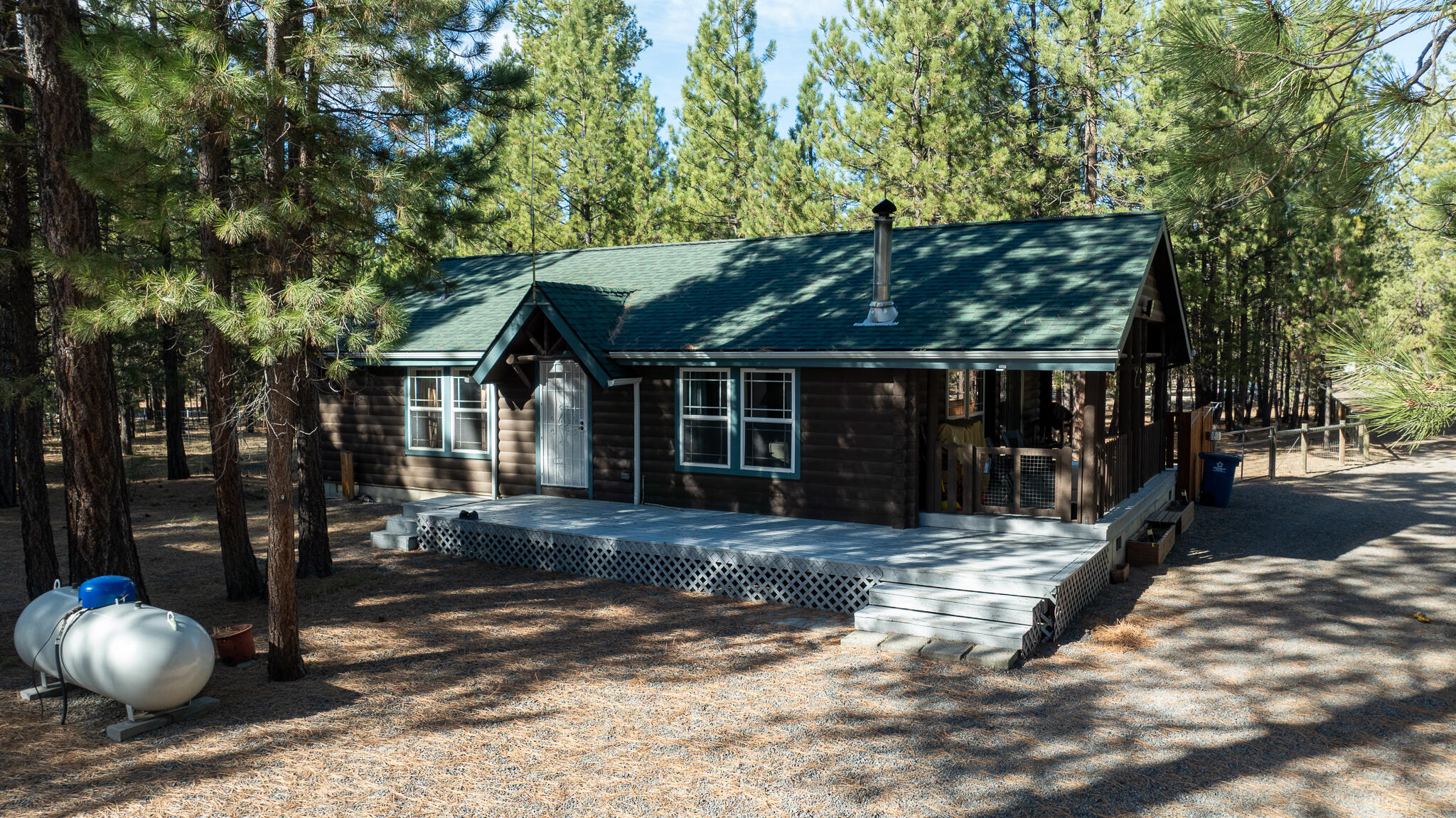 Settle into this well-maintained log-style manufactured home, where you can unwind by the cozy wood stove or take in peaceful forest views from the covered front porch. With over 10 private acres and direct access to public lands and trails, this property offers the perfect blend of adventure and serenity.
Recent upgrades include a new roof and all-new plumbing, giving you peace of mind and added value. Storage and workspace with a 960 sq ft detached garage that includes a third full bathroom, laundry hookups, and electric heat. You'll also find a 1,080 sq ft shop with a separate storage room, loft, and two 360 sq ft lean-tos, plus a 640 sq ft RV shop. Whether you're hosting summer nights around the firepit or heading out for a trail ride, this home is your launchpad for outdoor living.