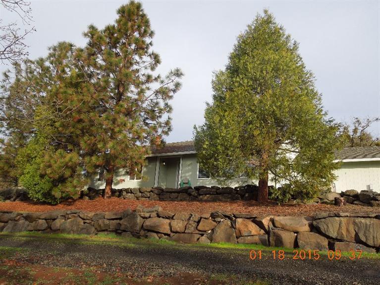 Ranch style home with view of the city night lights and panoramic mountain and valley views. Private but not isolated. Fenced pasture area with barn. Separate shop, 2 car attached garage, nice patio out back, concrete apron and walkways. Beautiful rock walls surround the home. Very well maintained 3 bdrm 2 bath home. High producing well, in-ground sprinklers and hot tub. Inside, vaulted ceilings, zonal heat and heat pump for year 'round comfort.