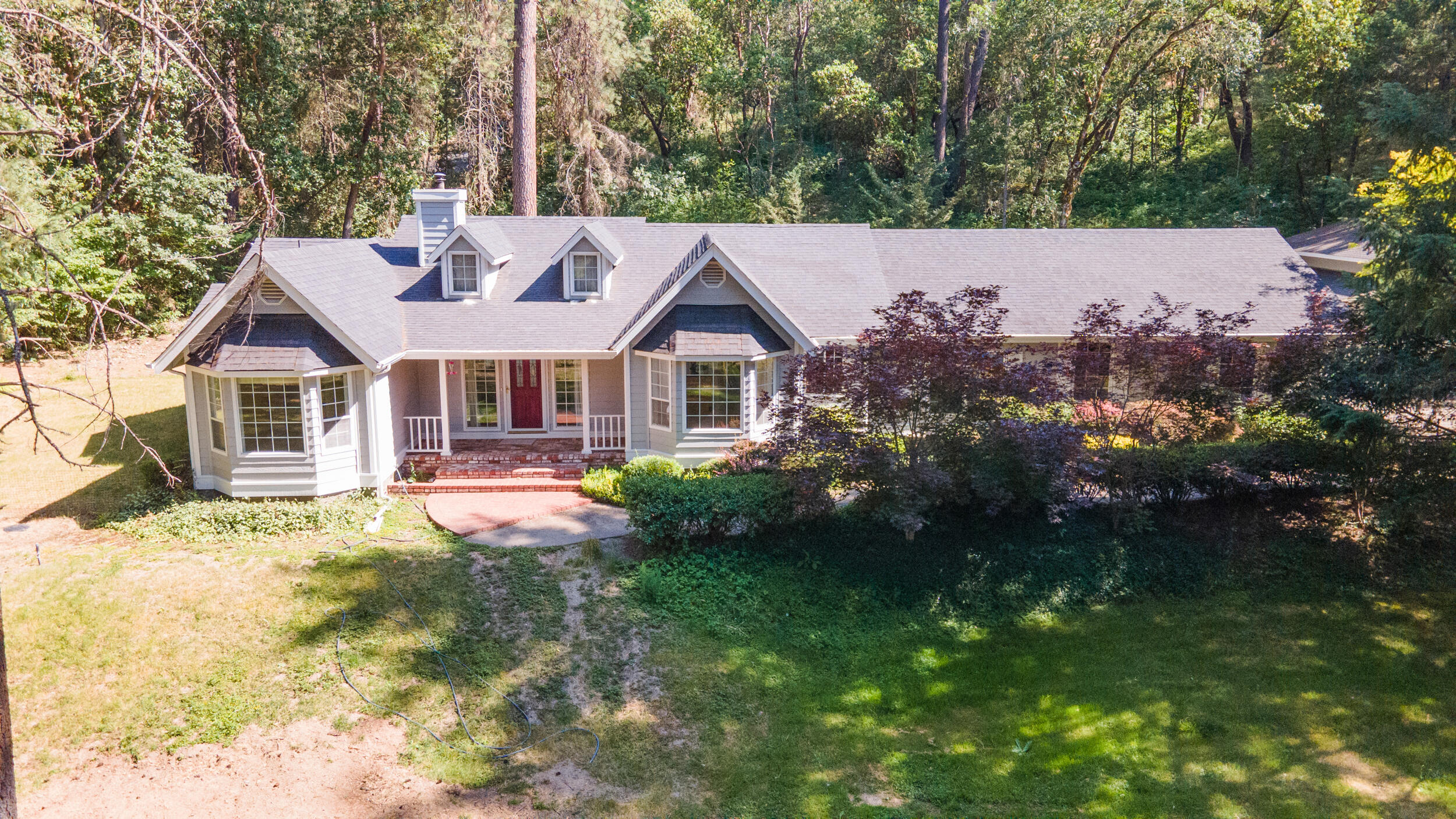Welcome home to your private and stunning 3-bedroom, 2-bath home on 1.7 acres, a rare find—just minutes from the peaceful town of Rogue River! Designed for both style and function, it features a spacious split floorplan with a private primary suite with exterior access, dual living spaces including living room with woodstove and family room with built-in office and wet bar, and both a formal dining room and a sunlit breakfast nook with gorgeous views. The kitchen and laundry are finished in elegant travertine, other features include new refrigerator, large island, pantry wall, and more! Storage is no issue with an attached finished 2-car garage and two oversized detached garages—one RV-ready with dual roll-up doors, and the other ideal as a workshop. A wired-in generator keeps vital systems running during outages and the well produced 30 gallons a minute when drilled. Relax by the peaceful backyard pond with waterfall—this home has it all, and then some!