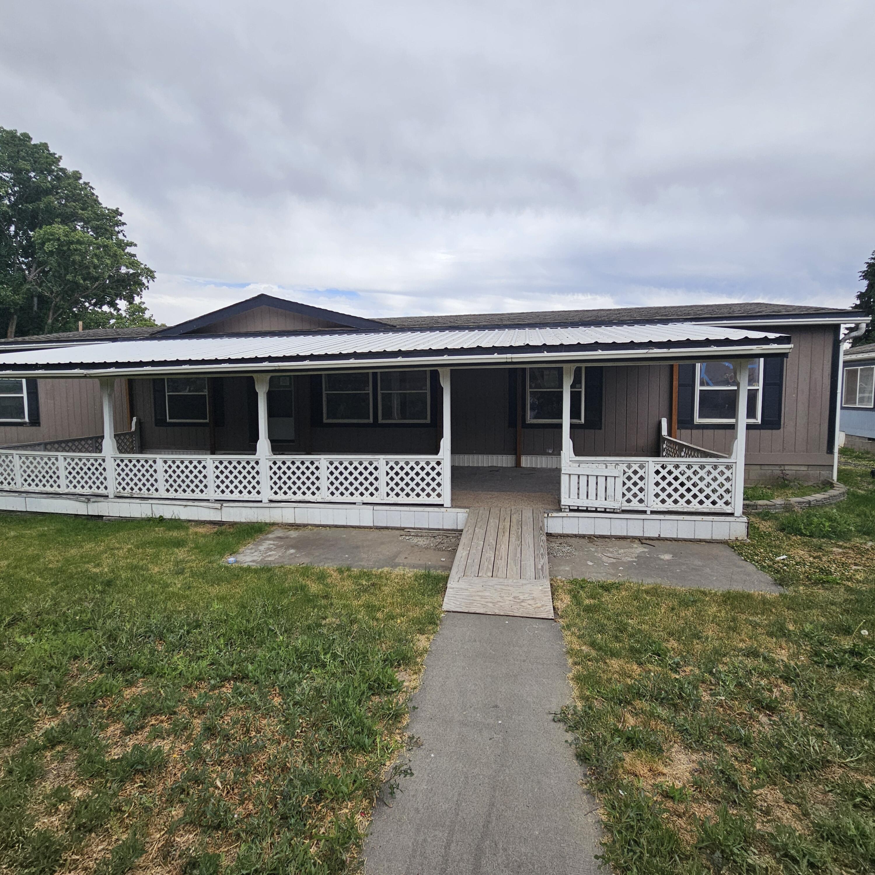 4 bedroom manufactured home is being sold ''as-is'' and needs intensive TLC. Located in town and offering a large front porch; and spacious living areas. This home has potential but requires  more than cosmetic updates, appliances, window repairs and furnace are needed. There may also be possible plumbing repairs. This is a great investment opportunity for the handy person, investor or DIY owner. Property as a residence is a legal non-conforming use; it is a residential home in a commercial zone. Buyer to verify with County what limitations if any this may create for their intended use. This property is a Foreclosure and is being offered as-is.