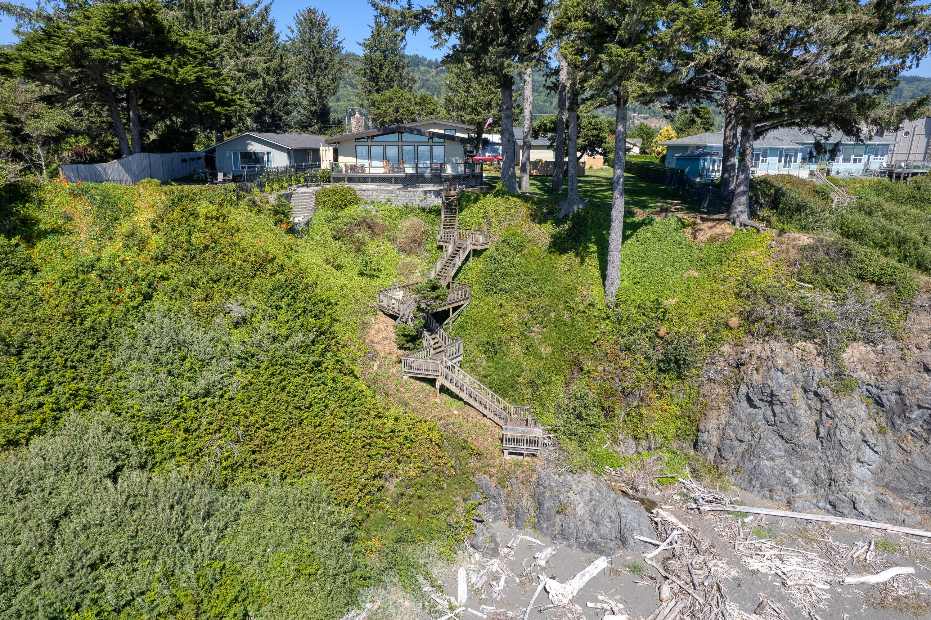 Incredible home on 0.96 acres of Oceanfront Land! This property has an amazing deck that leads to a putting green and stairs right to the beach. This home is newly remodeled with a primary suite on the main level. 32x32 RV Garage + third stall for boat, 1/4 bath/exercise room off the garage. Greenhouse, two tax lots. The main parcel is 0.7 acres plus the vegetation line parcel is 0.26 acres. Gated, fenced and private!