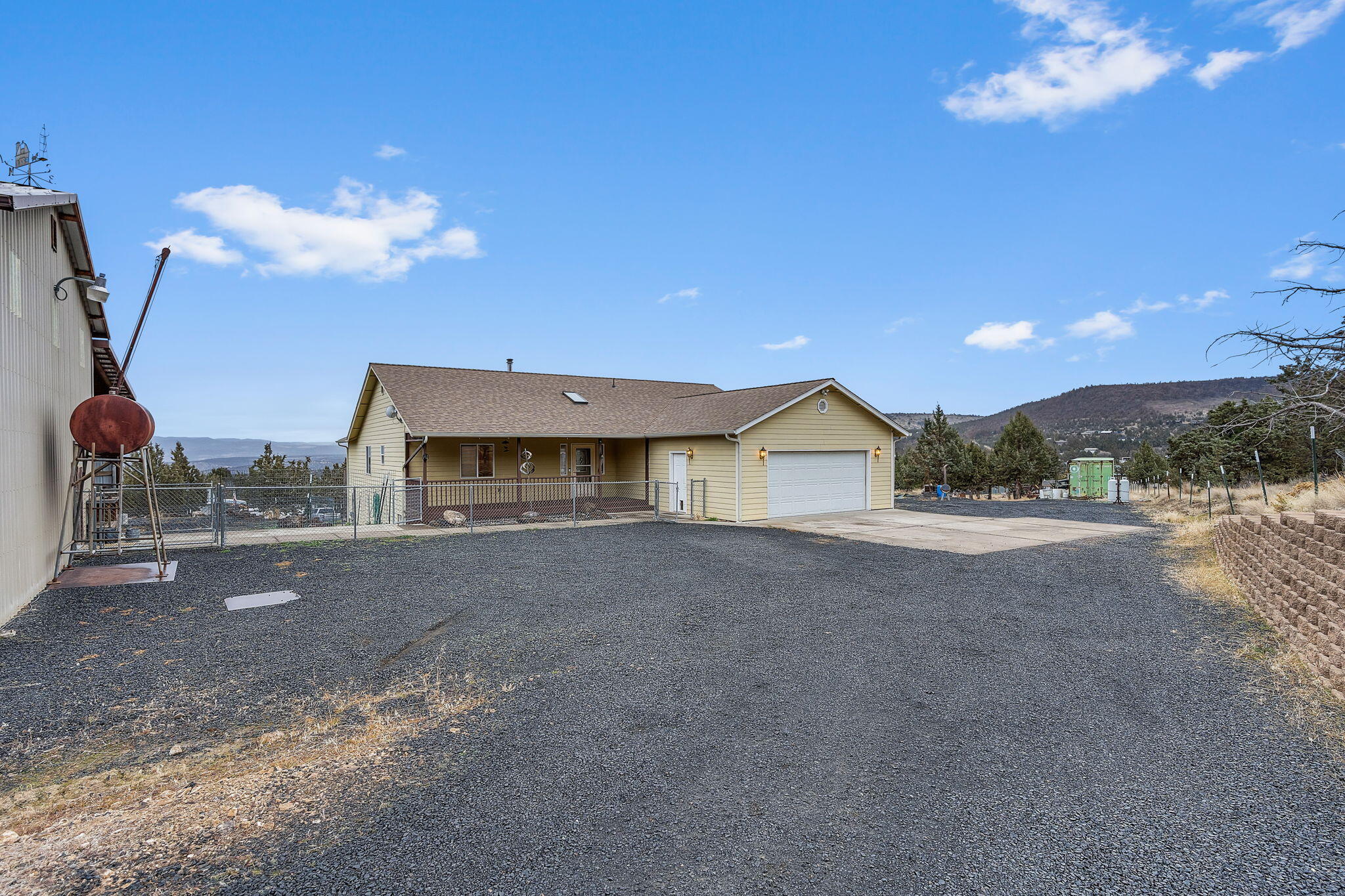 Discover the perfect blend of comfort, functionality, and room to expand on this spacious 1.85 acre property. The home features vaulted ceilings, vinyl windows, central air, a wood-burning stove adding cozy warmth and charm. Interior updates include new LVP flooring, and a functional layout ideal for everyday living. Outside, this property truly shines with a new roof, fenced yard, a 30x60 shop with an automatic garage door offering incredible workspace, storage potential, a loft, complete with both a wood-burning stove and pellet stove, plus a half bathroom and lean-to. Additional features include a greenhouse and shipping containers for storage The property may offer potential for horses (buyer to verify). Perfect for anyone seeking manageable space and versatility, this property is ready for its next owner!