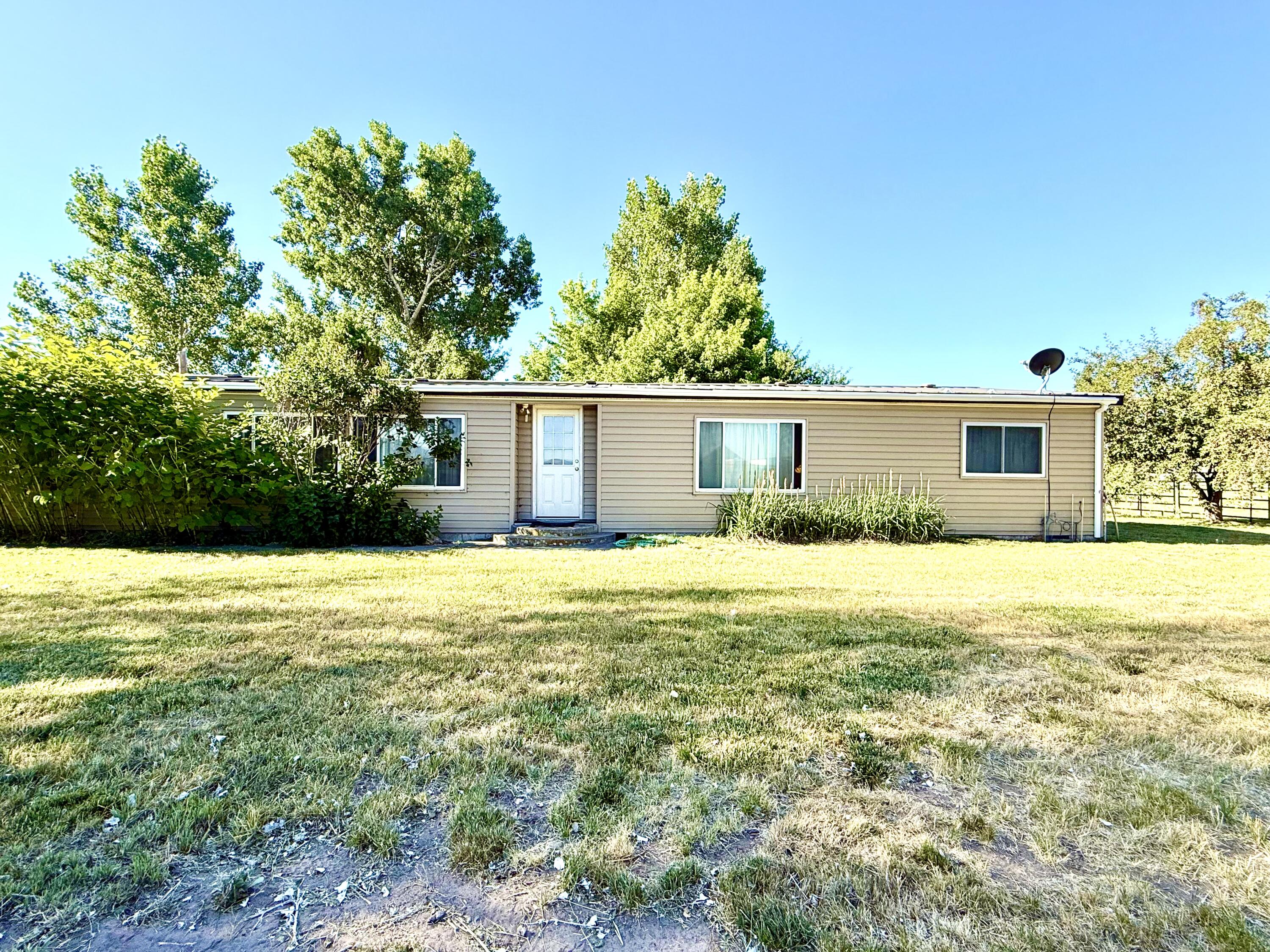 Nice Home with 17.48 Irrigated Acres! Come see this well kept property with a 3 bedroom 2 bath Manufactured home. Large front and back yard that is nicely landscaped.  Gated Driveway, sits back off the road for a quiet country setting! This property has a Shop and a 4 bay Hay Barn! All irrigation equipment is included. Approximately 14
acres is currently in Orchard Grass and putting up approximately 5 tons per acre. KID A Irrigation including a Wheel Line, Main Line, and Pump. The hay barn holds about
30 tons. Also inculded are horse paneled corrals.