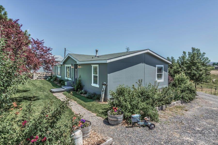 Country Cute Mini Ranch With Cascade And Rim Rock Views on 4.83 acres. The home offers a spacious kitchen with hickory cabinets, breakfast bar, slate appliances and wood flooring. Appealing open floor plan with master separation, recent paint in and out and a lg deck to enjoy as well. Mature landscaping w/lots of perennials, fruit trees & more. The shop is 40 X 40 w/12 door has a nice work room in the shop and there is a 16X40 addition w/stalls. The pastures are fenced and there are 4.8 acres of irrigation