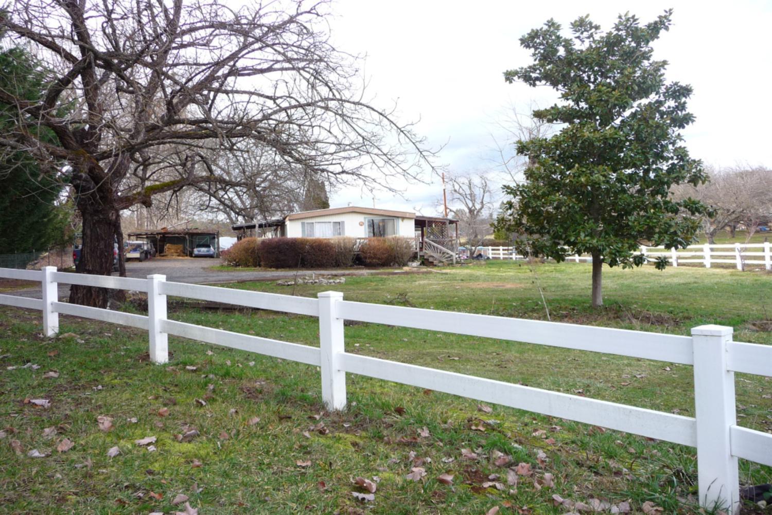 Prime, scenic, rural location between Medford and Jacksonville. surrounded by farms and ranch properties, including Dancin and other wineries. In recent years, beautiful custom homes have been built along Knowles Rd in the wooded hills around this property. This completely fenced property, with gate, has a 1980 double wide Manufactured Home with a deck, and a 444 sq ft shop. There is a 480 sq ft carport attached to the front of the shop and a 600 sq ft roof cover attached to the back. DEQ approved the 4 bedroom septic system in 1980, and the well flow was tested at 60 GPM when it was installed in 1988. The pasture has a gentle slope from the TID Irrigation Ditch on the west side of the property down to the east side of the pasture which mostly allows for a simple gravity flow system. There are 13 large walnut trees in the NW corner of the pasture that produced approx. 2,000 lbs. in recent years for some additional revenue.