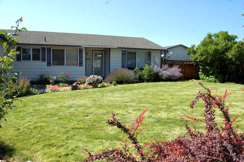 Investors take note! Comfortable cottage with built in Lessee for a year. 2 bedroom, 1 bath, 820 sq ft home built in 1974. Hickory cabinets, pantry area and stainless appliances make the kitchen sparkle. Open concept from kitchen to dining and living room areas. 2nd bedroom is being used for an office den with french doors. Slider from living room to covered patio & fenced back yard with garden area, raised beds and two storage sheds. Seller will have the roof replaced prior to closing. Nicely landscaped front yard with sprinkler system and room to park an RV plus single attached garage.