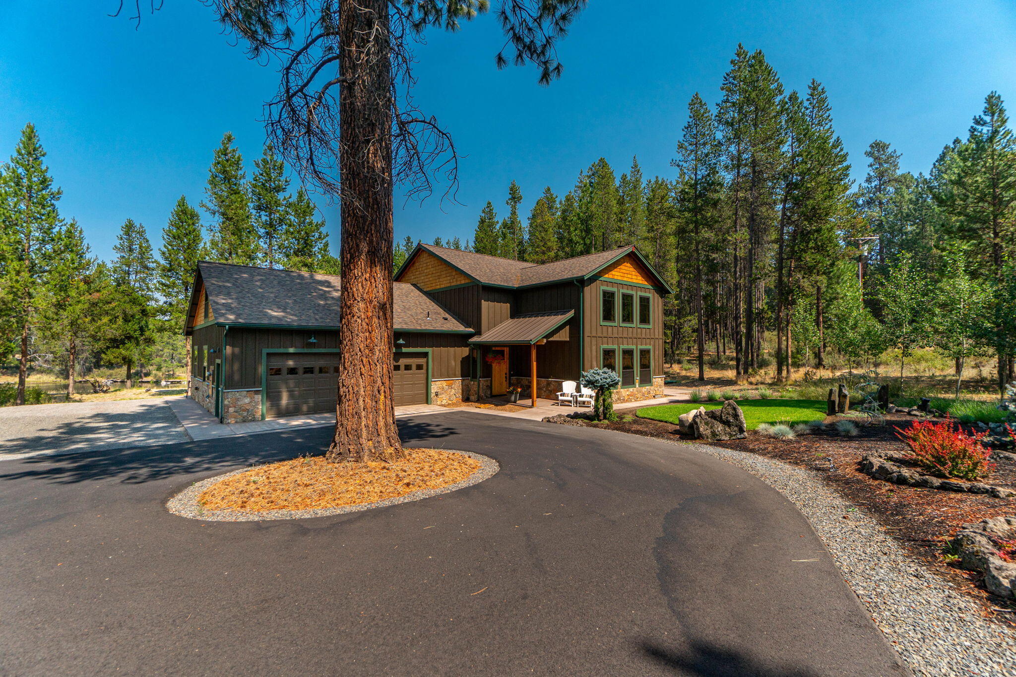Experience unparalleled luxury in this custom home on the banks of Spring River. Nestled on 1.02 acres, it blends modern elegance with serene nature. The open floor plan includes a bonus room and 3 spacious bedrooms, featuring 2 primary suites. The open kitchen includes black stainless appliances, sleek countertops, and knotty alder cabinetry. The living area has soaring 18' ceilings and wood wrapped black vinyl windows. Cozy up by the oversized wood-burning fireplace with Montana mossy rock and juniper mantle, creating a lodge-like charm. The oversized heated garage is a haven for hobbyists, featuring two rooms with built-ins and epoxy flooring, providing ample space for your vehicles and outdoor toys. Outside, enjoy serene views from private decks, a backyard firepit, and horseshoes. Park your RV in the dedicated area with a 30-amp hookup. The proximity to Sunriver adds to the allure, offering endless recreational activities, dining, and entertainment options just moments away.