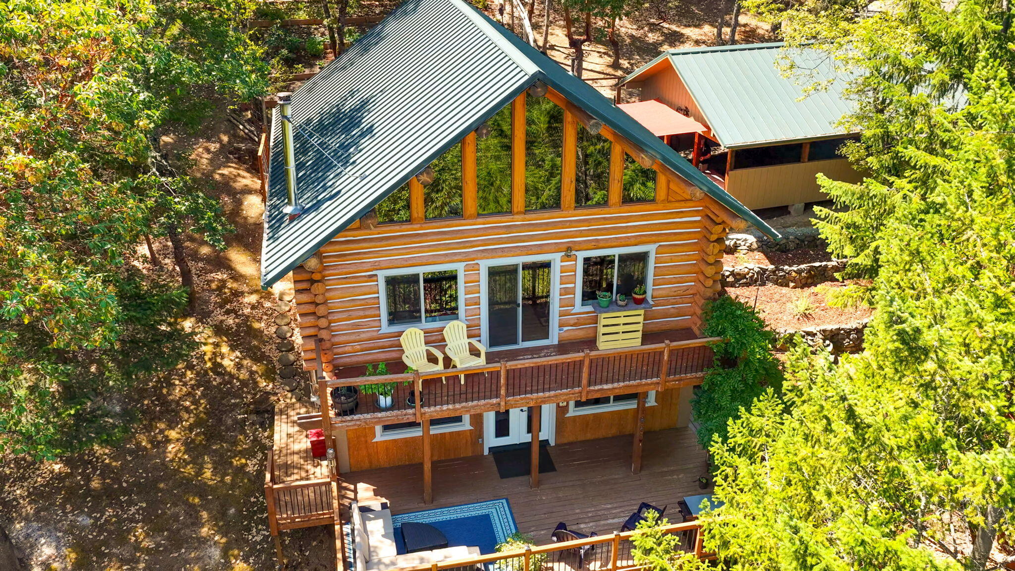 This pristine Log home sits on 5 private acres nestled in the sought after Griffin Creek area. The home is surrounded by abundant wildlife, trees & wild flowers. From the three decks you can take in the sprawling Mountain views all day and watch the glistening city lights at night. The bright, open-concept layout invites natural light and scenic views, while vaulted ceilings, wood textures, and certified wood stove create a warm, welcoming atmosphere.  Enjoy maple kitchen cabinets, Corian counters, custom light fixtures & a metal roof. Flooring includes Italian ceramic tile, pine plank & hickory flooring & Armstrong Laminate.  Recent updates include a 20x24 Garage/shop built in 2022, HVAC, windows, doors, Trex decking, gutters & more.  The well provides 7-10 GPM and there's an additional in-ground 1000 gal holding tank. There's also an artist's studio mini cabin.