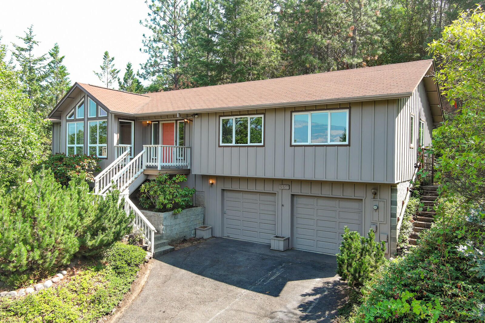 Contemporary home with tongue and groove vaulted, beamed ceilings, big floor to ceiling windows and mountain views set on .29 ac lot. Enjoy the cozy spaces in this 1993 built house with 3 bedrooms + office, 2.5 bathrooms, spacious den, and sunroom, lower-level craft/office with attached powder room. The eat in kitchen features plentiful storage, in a wooded setting are just a few of the custom features of this property. The primary suite is spacious and private set toward the back of the house and away from the living spaces. Terraced back yard accessed by a lovely deck and patio has mature plantings and provides a quiet and serene place to relax. Enjoy the nearby hiking trails and be just a few moments from close by shopping. Attached 2 car garage with add storage.