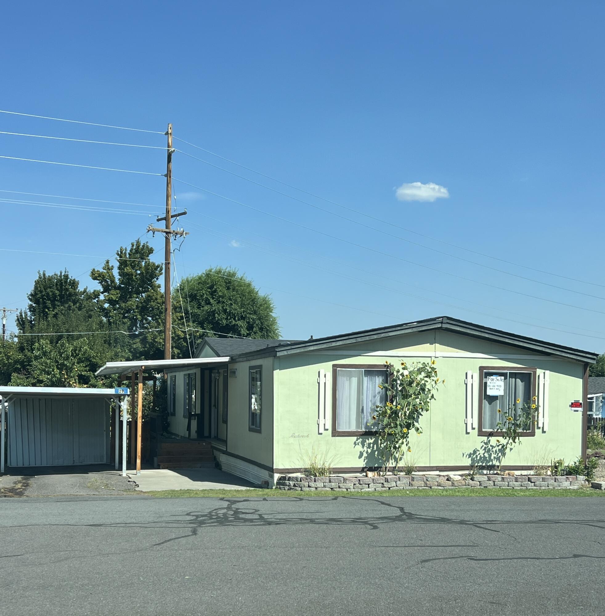 Partially updated three-bedroom, two bathroom manufactured home in a clean and quiet family-friendly park. This home sits on a nice sized lot and is in great condition for its age. The roof is about a year old and the laminate flooring is about 5 years old. This home has a great split floorplan with primary bedroom and en suite bathroom on one end and two bedrooms and a bathroom on the other end with the kitchen, dining, and living room (with a pellet stove) in the middle plus a large laundry area. This kitchen is spacious and has a newer convection oven and electric stovetop. The outside has some nice features...a mature fruit tree, berry bushes, a nice deck for entertainment and outdoor relaxation/enjoyment, a carport with a storage shed and a large shed with shelving in the backyard. This is in a cul-de-sac location with visitor parking directly across the street.