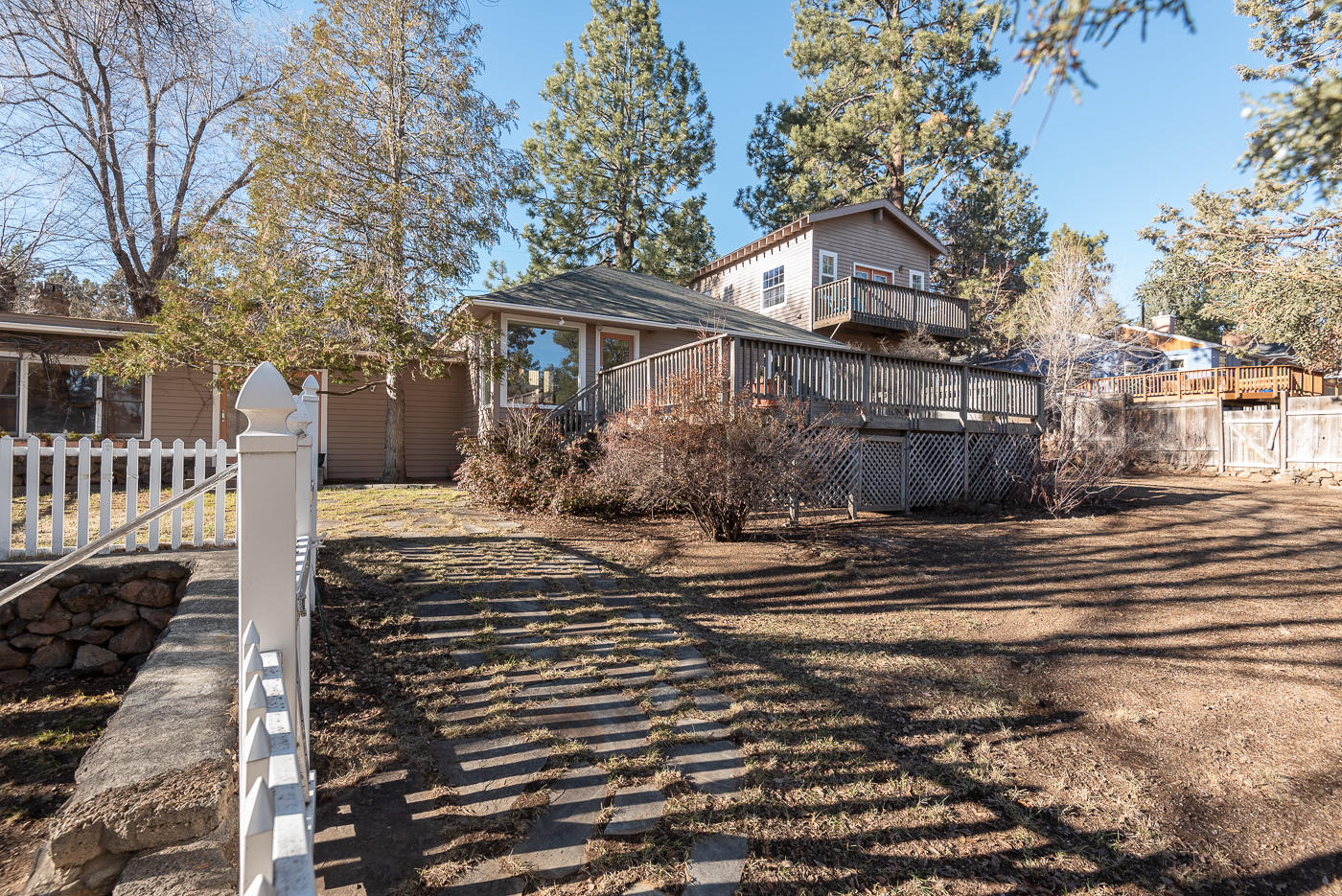 Rare find in the West Hills in the Bend View Addition neighborhood. Charming classic NW Bend home located on large quarter acre corner lot with old growth trees. Fantastic sought after location in Bend's core Westside with close proximity to everything the Westside and Downtown Bend has to offer. The 1,410 sq.ft. main home features a living room, family room, kitchen, eating area, 3 bedrooms, full bath and laundry room with abundant natural light throughout. The detached oversize single-car garage features sink, extra storage, wall heating, full bath plus an additional light and bright heated 504 sq.ft. of living/flex space above with French doors leading to a deck that overlooks the property. Fully fenced yard with room to expand and large back deck perfect for outdoor entertaining. This home and lot offers many possibilities, whether being a great rental investment property or to make it your own.