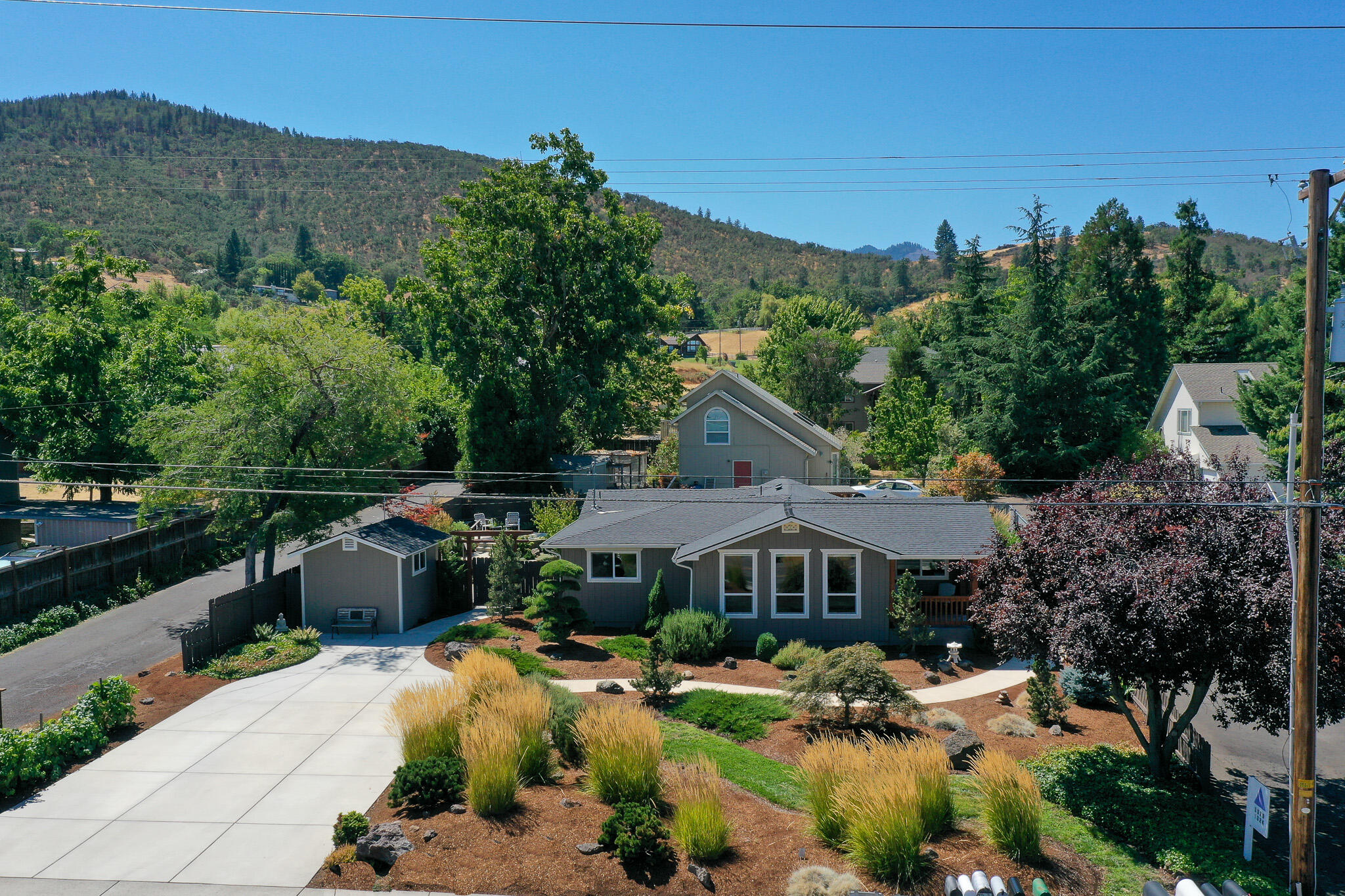 Enjoy your own Zen Garden. Located at the south end of Talent and a close 5 minutes to Ashland, this single level home offers a truly beautiful living space. The home has
been lovingly and tastefully remodeled over the last several years by the current owner, including updated electrical, plumbing, roof, paint, etc. The interior offers a
spacious kitchen with custom granite countertops, tile flooring and updated fixtures.Hardwood floors in many rooms, vaulted ceiling in living room, designer paint touches throughout the home. The primary suite offers a coffered ceiling, lots of storage, extra large bathroom with custom tile work. The exterior is a work of art with mature low
maintenance high quality plantings, irrigation system installed, lots of walkways and sitting areas, large custom pergola and privacy. Tiled covered front porch.This is a beautiful and unique home
and property and a pleasure to show.
