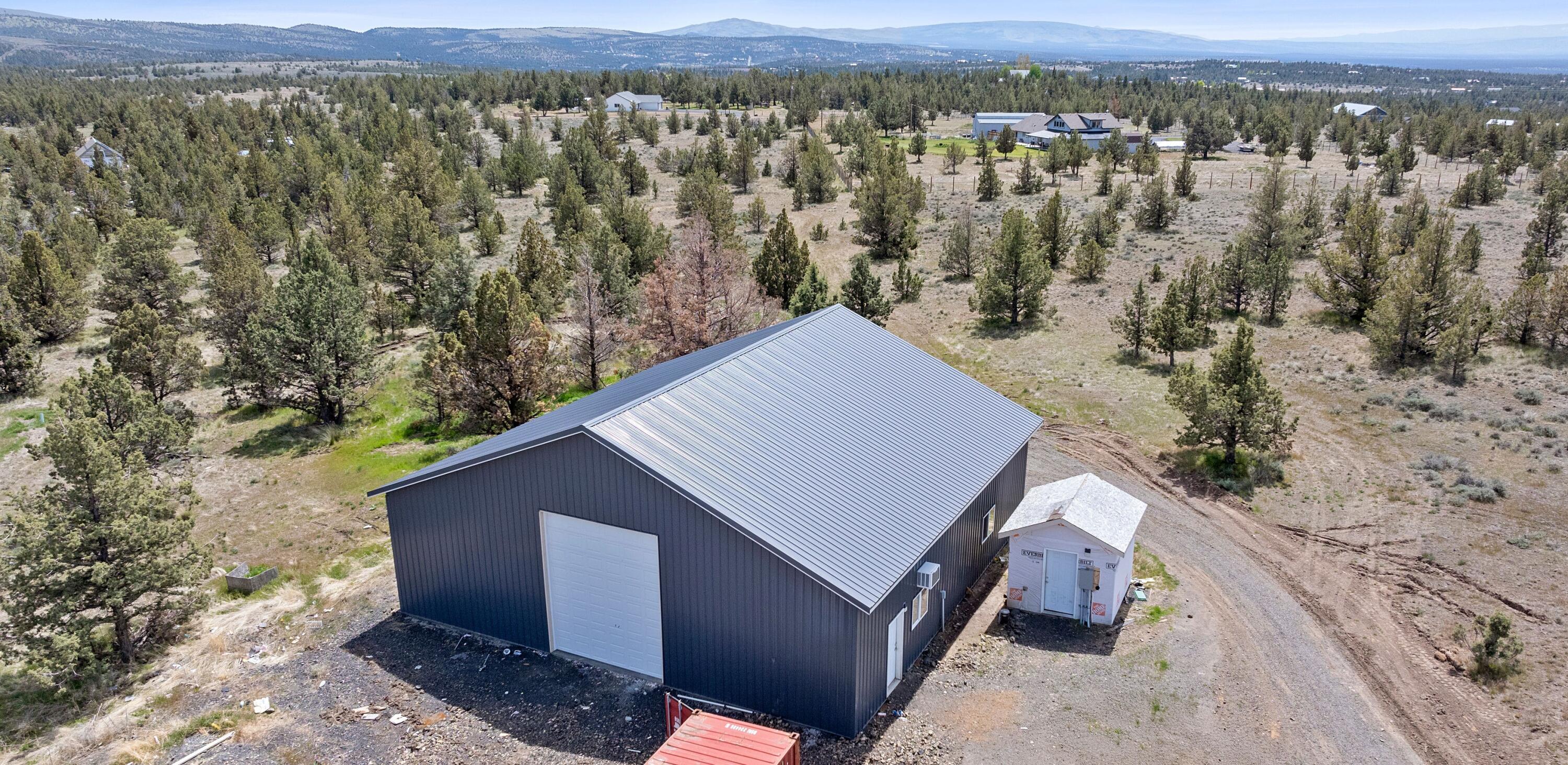 5 acres of mostly flat and gently sloping land.  Tree line runs along one border where a runoff creek forms seasonally.  48x48 stick built shop with 16-inch spaced studs.  Two 14-foot automatic rolling garage doors with specially built trusses to allow a class A motor home to pull in and through.  350 ft deep well with 27 gallons per minute.  400 amps of electricity with a 50-amp and 30-amp hookup at the power pole as well as power to the shop and well house.  Septic system with RV hookup access.  1200sqft fenced dog run with small shed.  Easily accessible driveway for RV or trailer with well-established packed rock.