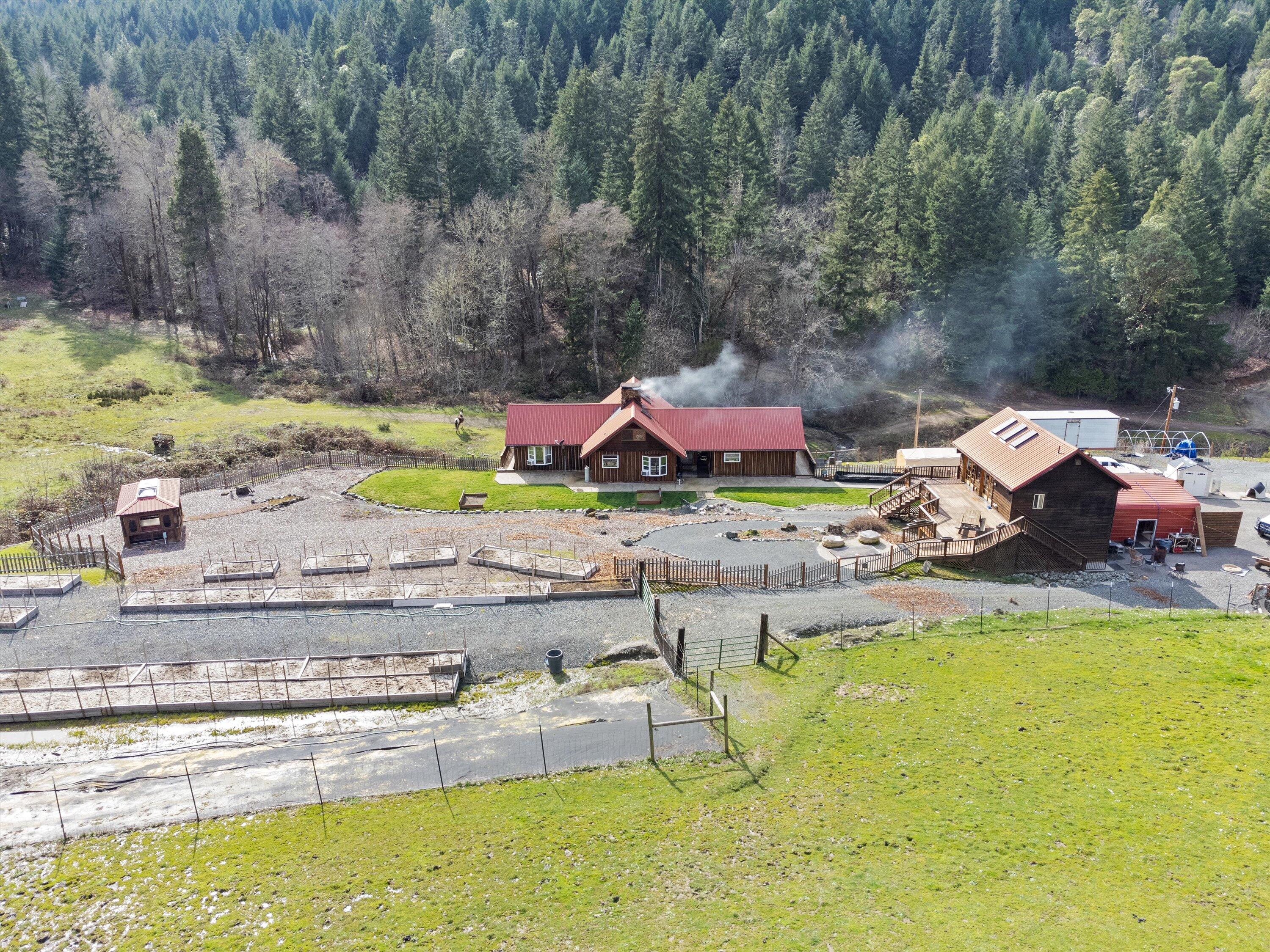 Dream homestead on nearly 30 private acres with 2 creeks backing up to hundreds of acres of gorgeous forested BLM land! This home is a perfect blend of historical charm and modern amenities. Built with log siding milled from the property, entry floors made with stones from the creek beds, hand scraped hickory flooring, and antique wood adorning the interior finishes. The fully fenced/ cross-fenced property includes a guest house, barn, tiered garden, hot tub house, multiple pastures, workshop, garage, RV parking, and multiple outbuildings. Picture windows overlook the tiered deck, creeks, and forest. The stone fireplace and log details scream ''cozy'' and whole house generator keeps the main house and guest house fully functional through emergencies. The kitchen and bathrooms were thoughtfully updated in 2016 with granite countertops, tile, and updated appliances. There is a loft above the kitchen, additional living space downstairs.
$5,000 credit offered!