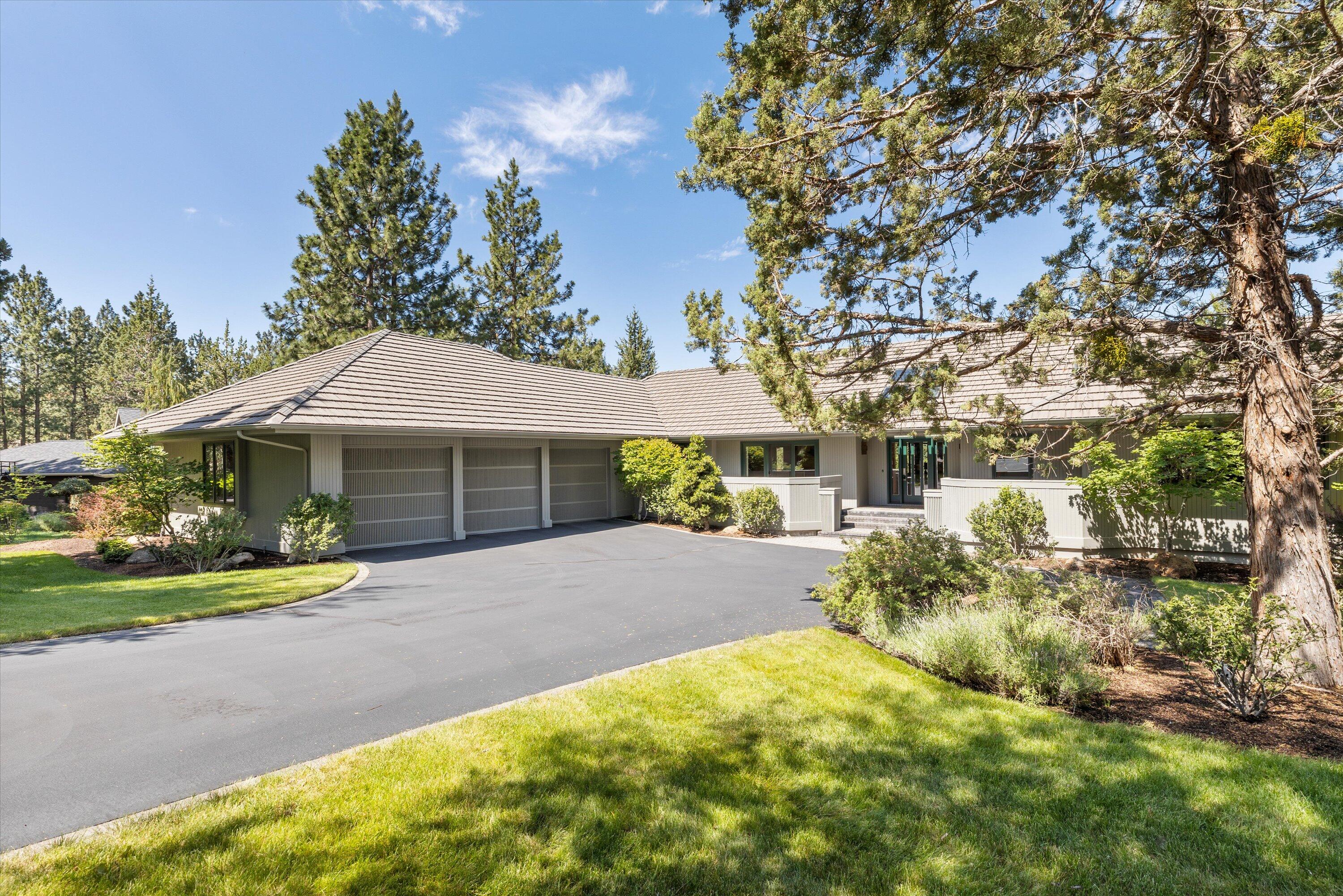 Enveloped by the stunning Three Sisters, entering this single level residence you immediately know you belong. The peaks are visible from almost every room. Extensive quality woodwork throughout including wood wrapped, metal clad windows, solid core doors, custom builtins. Thoughtfully designed open concept floor plan w/ primary suite separation. Granite counters, temperature controlled wine area, large island, coffered ceiling & deck access, this kitchen has space for it all!  A great room w/ incredibly mastered vaulted ceiling is ideal for entertaining or sitting by the fire & gazing at the peaks. Primary suite affords two large walk-in closets, marble bathroom, deck access & of course the incredible view. Designated office is complete w/ extensive built-ins. Dining room opens to front patio-the ideal spot for enjoying coffee while watching the sunrise. Three car garage is a car lover's dream complete w/ natural light, outdoor access & flat driveway. Abundant storage.