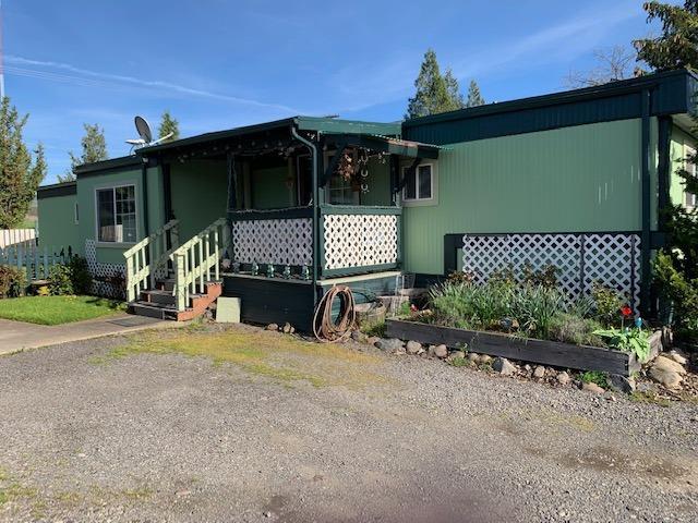 Low cost living in Ashland is possible. This 3 bedroom, 2 bath home in popular all-ages Bear Creek Mobile Park has a great location in the park. The space is large with a carport/workshop, shed & huge backyard. Guest parking & mail boxes are just across the driveway. A cute front porch has sliding doors into the dining area & kitchen. The kitchen cabinets have nice, upgraded wood fronts. The living areas & bedrooms have laminate floors. The floor plan is split with one bedroom & bath in the front of the home. The other two bedrooms are in the back of the home with tiled floors in the laundry area & the other bathroom in between. Out the backdoor is a storage shed & covered deck. The living room sports a 12'X7' tip out that adds useful space. Space rent is $400/month & includes water, sewer & garbage. You'll find lovely views of the mountains. There is a large, grassy area near the manager's space that is great for picnics & play time. Close to town but with a country feel.
