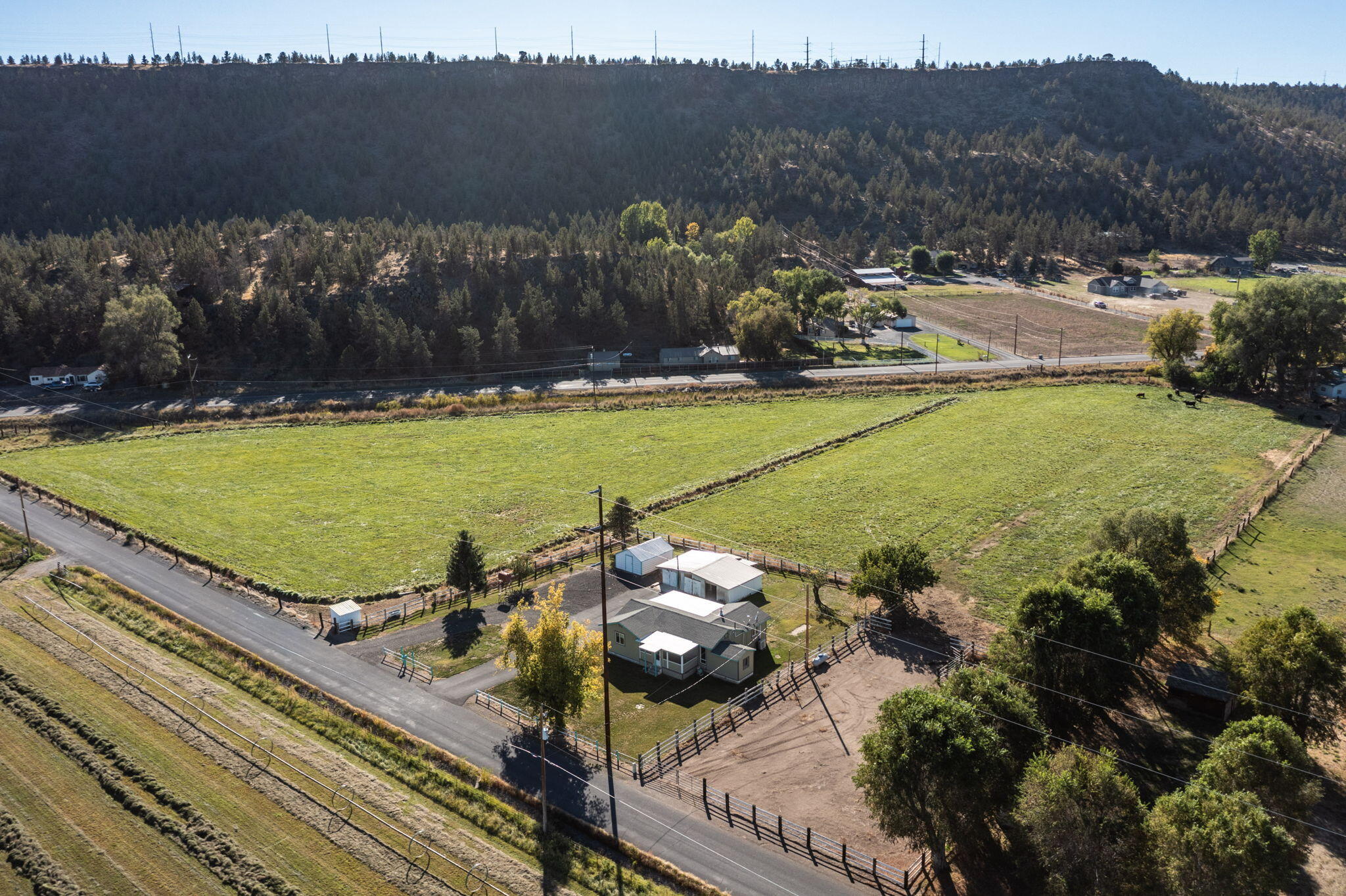 Rare opportunity! Peaceful country living w/ irrigation rights & horse amenities. Escape to this charming 2 bed, 1 bath home w/ bonus room, nestled on 6.6 acres w/ valuable irrigation rights, surrounded by mature trees & amazing views. Whether you're looking for a hobby farm, horse, cattle, or alpaca property, or a quiet rural retreat, this one checks all the boxes. Enjoy easy flood irrigation that keeps the entire pasture lush & green, perfect for grazing or gardening. Land is fully fenced, complete w/ large workshop, corral, stable w/ 2 stalls, & hay storage. The home features covered front porch w/ beautiful views of surrounding farmland, ideal for morning coffee or sunset unwinding. Inside, the layout offers cozy living spaces & versatile bonus room. Large workshop provides ample space for tools, projects, or storage, making this property as practical as it is peaceful- & even comes w/ a riding mower! Located in a quiet rural setting w/ room to roam.