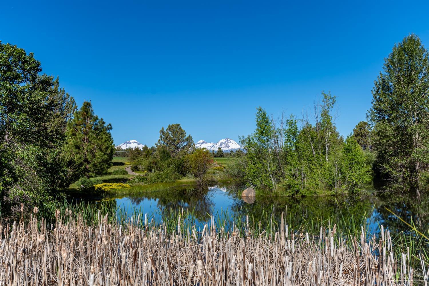 This warm and spacious traditional country home in Tumalo is tucked away in a private grotto opening to the west like a private amphitheater with spectacular views over irrigated pastures to the cascade mountains. There are 48 acres with lawns, gardens, and fields which are meticulously cared for with a large pond including dock and gazebo, as well as a small bunk house and shop/barn. The two level 5,415 sf brick home includes 4 bedrooms, 3 baths, large open kitchen with granite counters and 12' island, living and family rooms, private office, and special, one of a kind wine cellar or he/she cave. Pool table included; llamas and alpacas, optional.