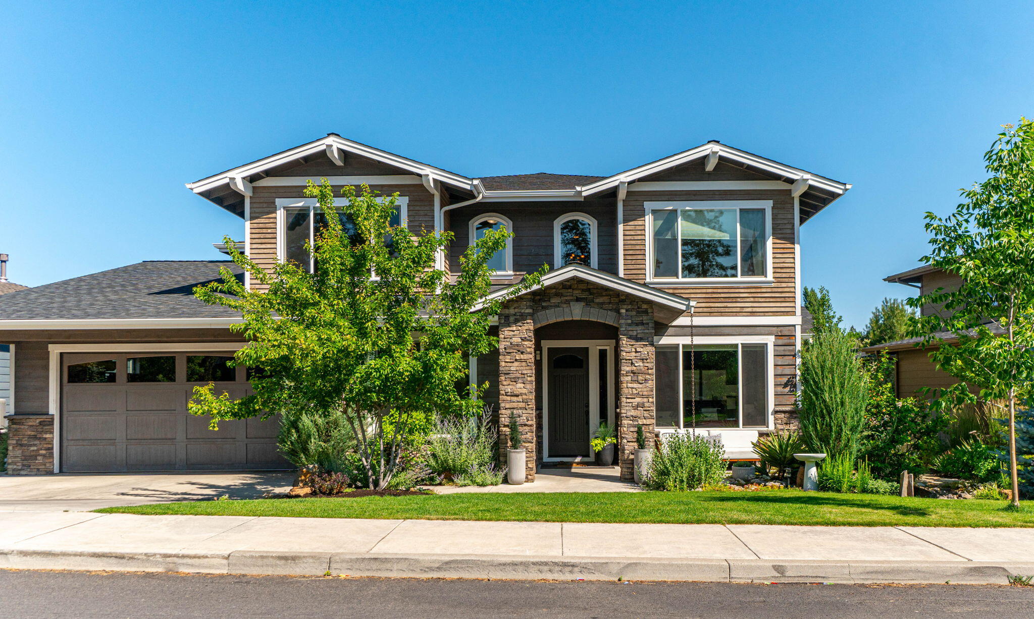 Welcome home to SW Bend and the desirable River Rim neighborhood. This Northwest Craftsman residence blends tried and true design with modern comforts. Once inside, you will discover an open floor plan with good natural light, showcasing fine craftsmanship and high end finishes. The spacious living areas provide ample room for entertaining. The heart of the home is the gourmet chefs kitchen with stainless steel appliances, custom cabinetry, and a large island that invites gatherings. One bedroom and full bath are appointed on the first floor of the home while the generous primary suite and other bedrooms are upstairs. One of the standout features of this home is the oversized, four-car garage that provides plenty of storage and flexibility. Outside, the beautifully landscaped yard and covered patio offer a serene escape for both relaxation and entertaining. Situated in close proximity to shops, schools, parks and the Deschutes River Trail, this is an opportunity not to miss.