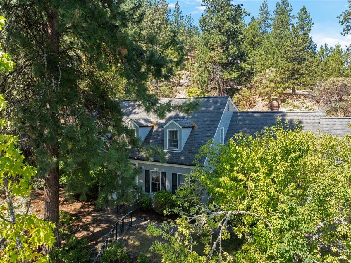 This Mountain Park Estates home represents one of the few Cape Cod style homes in Ashland. The 2697 square foot home provides 4 bedrooms, great separation of space, and plenty of storage. The large, remodeled kitchen offers quartz counters, an island, and a double stainless-steel sink. The owners added stunning oak floors. The large formal dining room is great for entertaining. The living room has a wood burning fireplace. The second level primary bedroom contains a second fireplace, ceiling fan, and a remodeled bathroom. The guest bathroom is also remodeled with tile floor, shower, and tub.  The home is perched on a large, .41-acre private lot. The yard features an in-ground swimming pool, fruit trees, garden beds and a fenced dog run. The two-car garage is oversized. This versatile home is a must see for anyone that appreciates the traditional style of the Cape Cod home.
