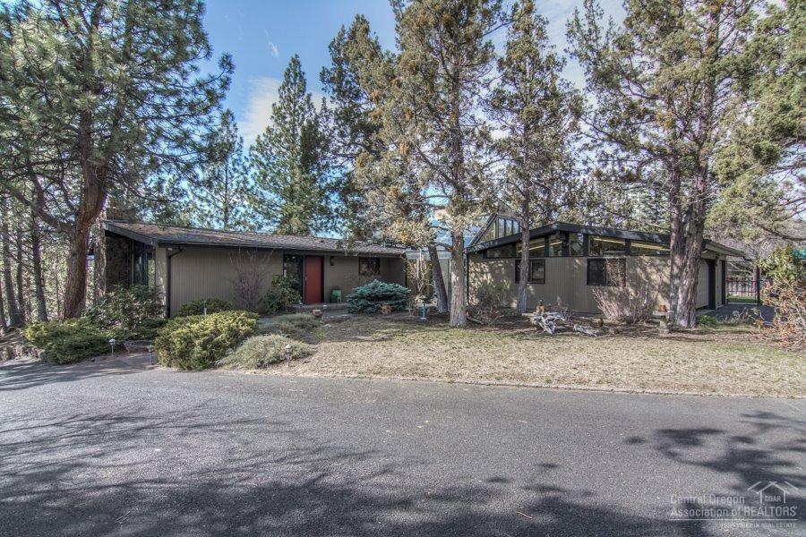 Authentic Mid-Century Modern inspired Atomic Ranch style home built in 1968 on an elevated and private .91 acre lot centrally located in SE Bend truly captures the vintage of the era. This single level home screams style and sensibility w/gorgeous woodwork, huge dbl pane wood wrapped windows, concrete floors, floor-to-ceiling lava rock gas frplce and lots of outdoor living space. 2 in home offices separate from the 4 bdrms. Private driveway entrance. Cascade Mtn views add to the wonder of this property.