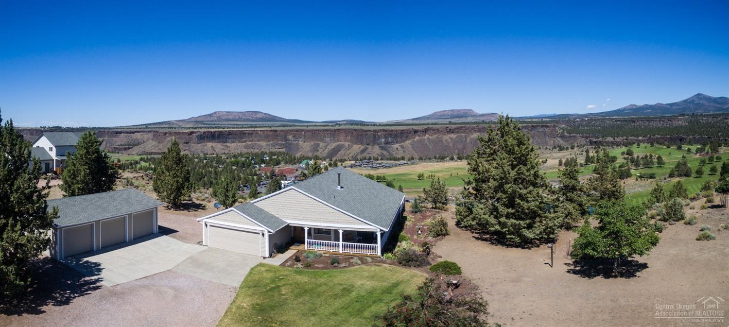 LOCATION, LOCATION at the entrance of Crooked River Ranch, overlooking the 18-hole golf course, surrounding buttes, & green farmland across the Crooked River Canyon. Truly a postcard setting, seen through walls of windows or from the wrap-around covered porch w/hot tub. Hardwood floors, pine tongue & groove vaulted ceilings & a beautiful stone hearth, ready for your choice of secondary heat speak to the comforts of home. In addition to attached 2-car garage, is a 3-car garage-shop. You won't be disappointed