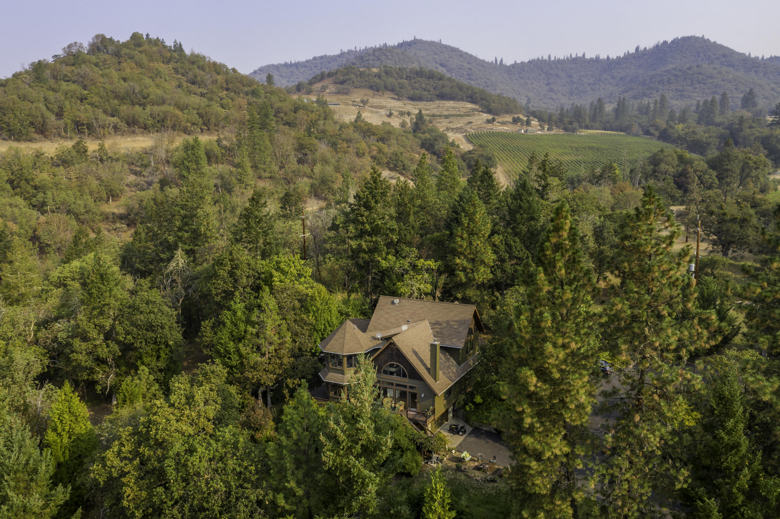 Secluded 15 acre Applegate wine country property with gated and paved driveway leading to a custom home with endless features. Starting with a carved mahogany front door, custom passive solar south facing property, 20 ft ceilings in the great room next to a designer kitchen, with a 135 inch long granite island. Arched entries make their designer statement, and every room features Gienow wood windows and doors framed by dark recycled wood that look out to incredible views.4 Bdrms 3 bathrooms with marble/slate floors and antique English vanities. Oak floors flow throughout the main living area. 2 carved wood gas fireplaces are stunning features plus a wood stove surrounded by stones. Upstairs are two private bedrooms, office, and library, you see expansive views from every window in this dream home.  24 gallon well 2 heat pumps 2400 square-foot shop that contains a private guest quarters. The property features mature gardens, meadows and forest with 2 seasonal creeks