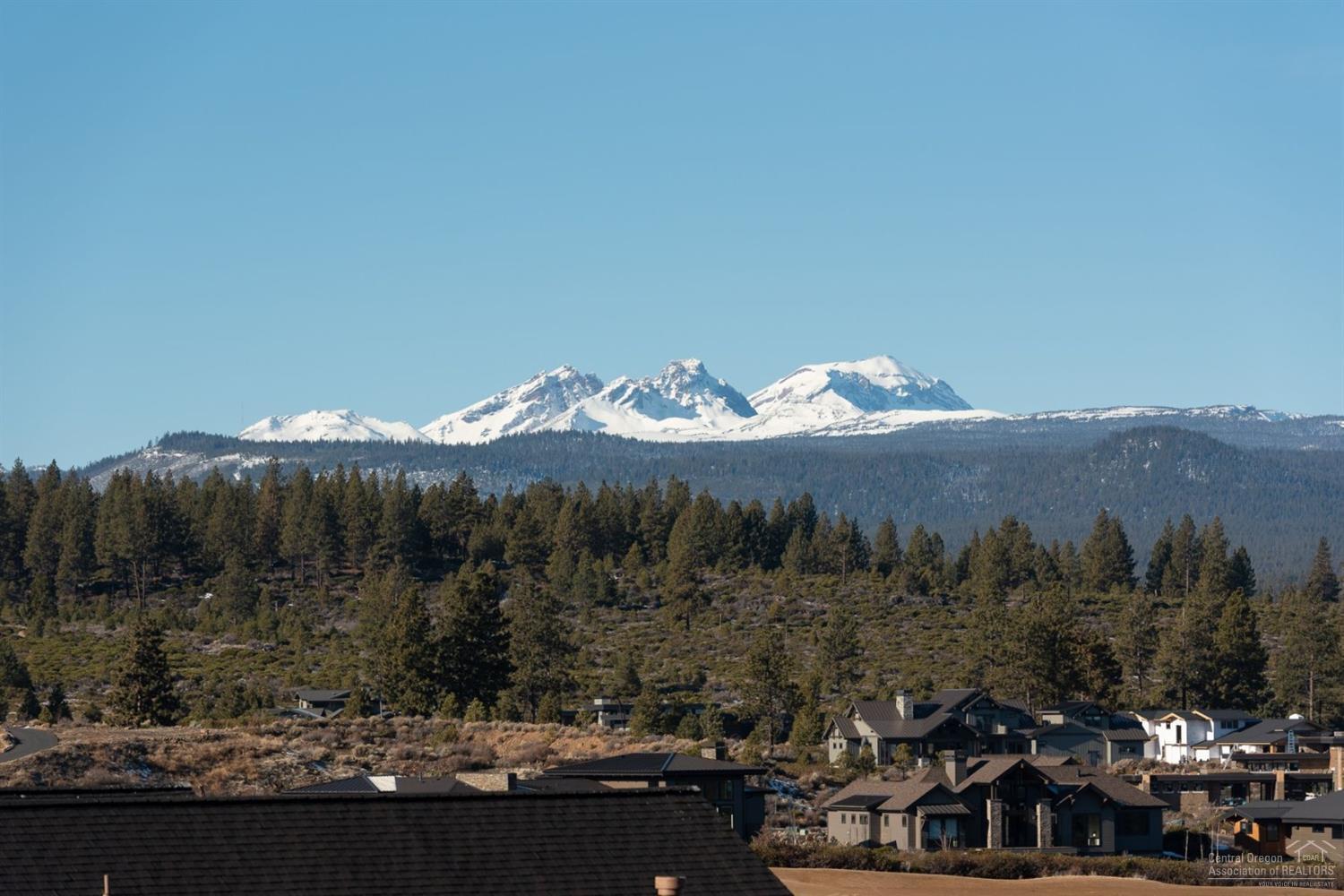 This stunning premium view lot with Cascade Mountain and golf course views is conveniently located on The Rim near the Tetherow clubhouse, fitness center, pool and three restaurants. Main floor master suite with fabulous bath; gourmet kitchen opens to impressive great room with large covered balcony that extends over to master suite. Main floor boasts den and 2 en suite bedrooms. Two additional suites and bonus room on lower level with patio. Fantastic location with Mt Bachelor and Phil's Trail at your door!