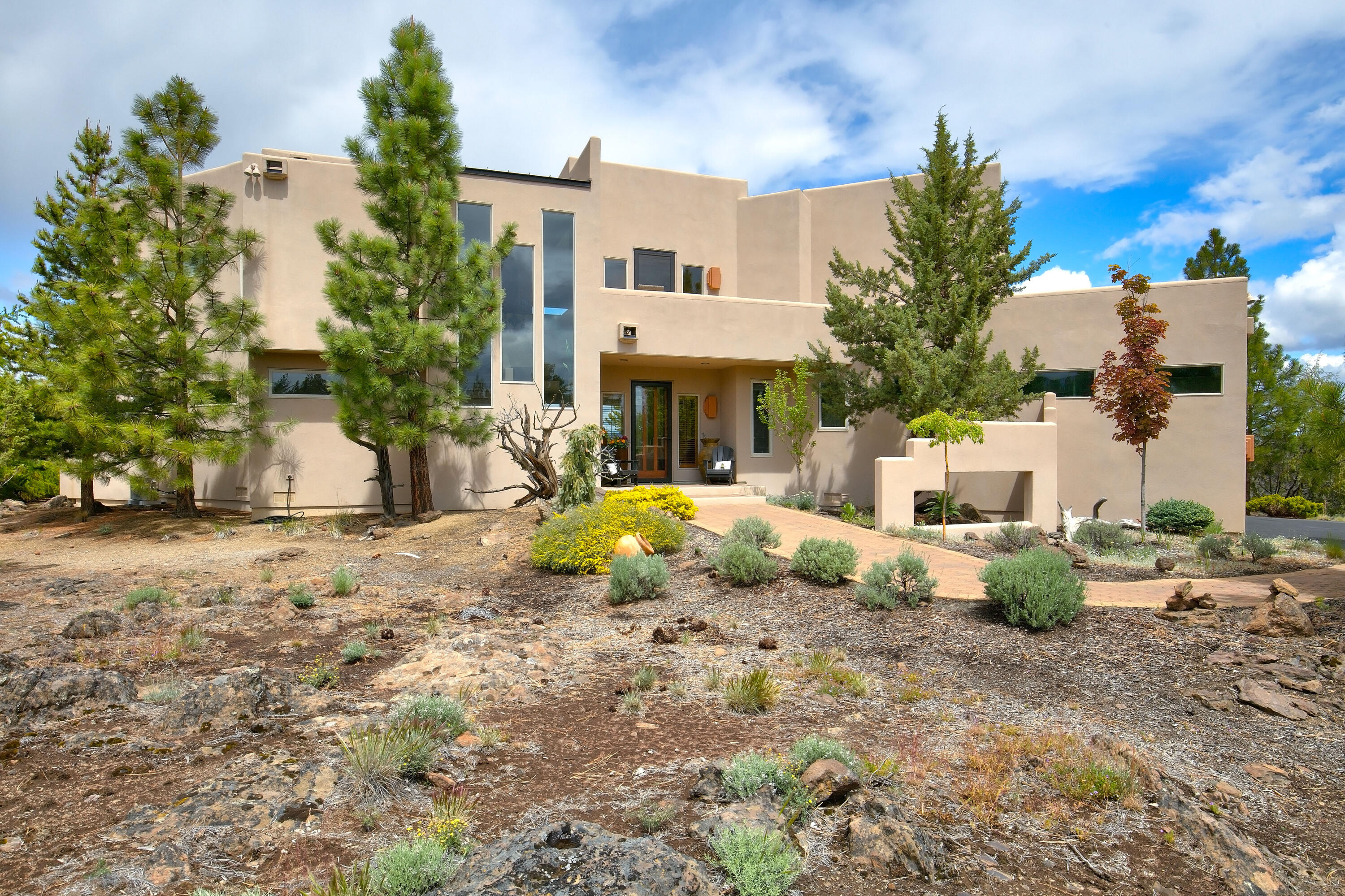 Southwestern architecture on nearly 10 acres with views of both Black Butte & Mt. Jefferson in Sisters! Once you step inside of this custom home your eyes will be immediately drawn to the vaulted ceilings, floor-to-ceiling windows, Saltillo tile in great room and fireplace with reflective fire glass. This home is perfect for entertaining with an open floor plan, cook's kitchen and mezzanine wet bar. Outside, you'll find multiple decks to mix and mingle, outdoor dining area with fireplace and picturesque pond setting for all your friends and family to gather around. The den has a cozy adobe-style fireplace and a log-beamed ceiling. All three bedrooms feature ensuite bathrooms and outdoor patio access. Bordering Deschutes National Forest & protected access to Whychus Creek through Deschutes Land Trust. This special property has it all and is located only minutes from downtown Sisters!