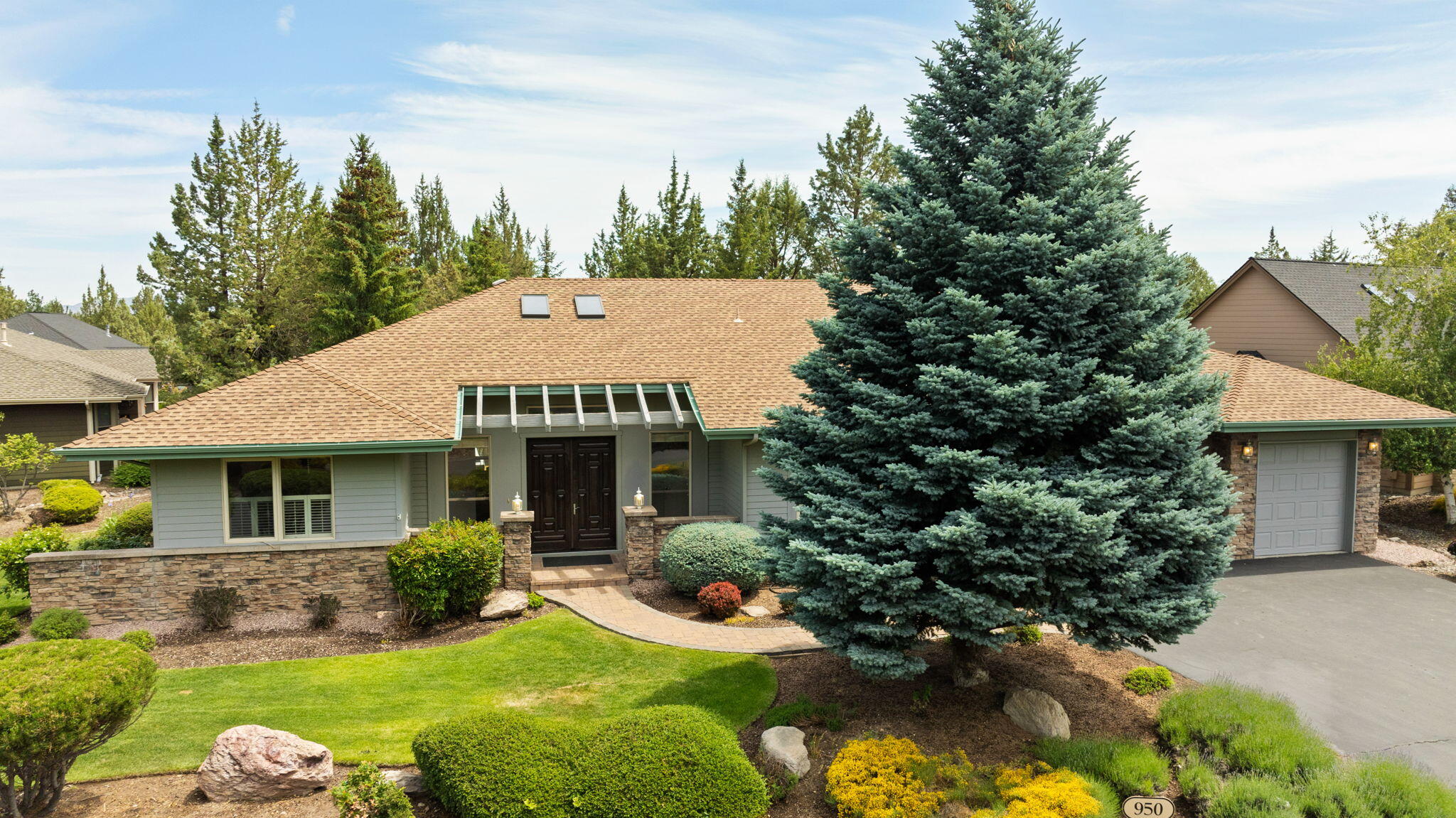 Featuring a brand-new HVAC system and a new roof, this beautiful, inviting single-level home offers 3 bedrooms, 2 baths, a den, and 2,557 square feet of light-filled comfort—all set on a peaceful, tree-lined lot with a 3-car garage. The expansive great room welcomes you with vaulted ceilings, skylights, and a 3-sided fireplace that adds warmth and charm, while large windows frame views of the lush, landscaped backyard. Ideal for both entertaining and everyday living, the open-concept layout features a spacious kitchen with granite tile countertops, rich alder cabinetry, and an oversized walk-in pantry. The primary suite provides a quiet retreat, complete with its own fireplace, a cozy bay window, a large walk-in closet, and an ensuite bath with a soaking tub and dual vanities. A versatile den or home office and a tranquil cedar deck — perfect for morning coffee or unwinding in the evening.  Enjoy access to trails, 3 golf courses, sports centers, pools and year-round community events.