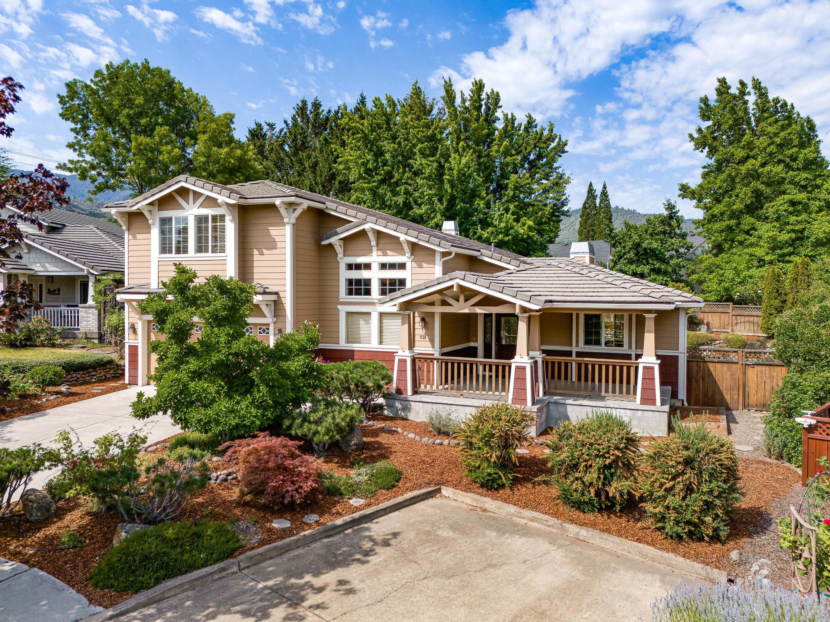 Discover the essence of tranquility in this exquisite home, where every detail enhances your daily life. Begin your day with a cup of coffee on the expansive covered front porch, overlooking lush gardens and mountain views. Step inside onto stylish tile floors that lead you to a den or formal dining room boasting soaring ceilings and large windows framing the natural beauty outside. To the right, a chef's dream kitchen awaits, complete with a generous island, granite countertops, and ample space for culinary creations. This kitchen seamlessly flows into an open living room and second dining area, perfect for gatherings. From here, step out to the covered back patio, ideal for summer barbecues, surrounded by meticulously landscaped gardens in the fenced backyard that adjoins open space. The main level also features an oversized half bath and a convenient laundry facility. Finally, retreat to the spacious and luminous master suite, where a corner gas fireplace adds warmth and charm.
