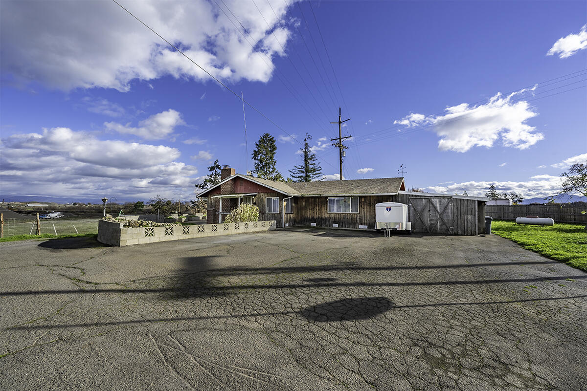 Incredible opportunity!!! Do not miss out on this chance to own an amazing farm property! Sitting on two tax lots, total of 3.15 acres, with incredible views of the surrounding mountains. This 3 bed 2 bathroom home allows you to live in the Country, but still have access to town with a short drive!  The home features 1,768 SqFt of living area, including a large living room with a wood burning fireplace, a kitchen with multiple sinks for convenience, large pantry & plenty of storage options! Enjoy country living at its finest with over 3 acres of land, perfect for gardening, animals, or outdoor entertaining. Property has its own well & septic system, and the land also features a couple outbuildings - Perfect for storing tools and equipment.