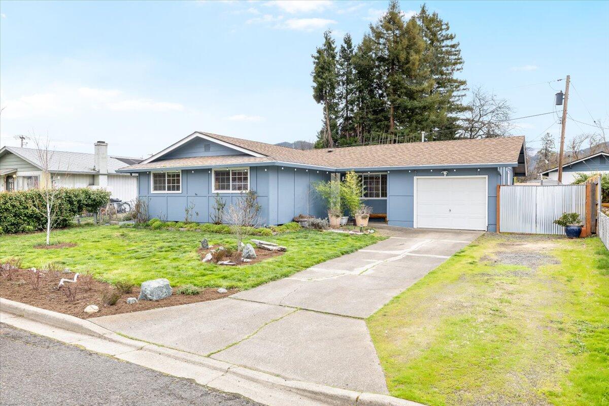 You will love this jewel box of a home set in a quiet and mature West Talent neighborhood, close to Talent Elementary and Talent Middle Schools. Solid and sensible mid-century construction, with hardwood floors throughout. Home has been lovingly maintained and painted in happy colors. Primary bedroom has a small en-suite half bath. Galley kitchen is well laid out, with good storage and workspace. The adjacent open dining area features a large sliding glass door which opens onto a covered wooden porch in the backyard. The backyard is a gardeners delight, with raised beds and several sheds, and a lawn area in the middle. Perfect for relaxing or entertaining! Single car garage is perfect for your vehicle, extra storage, or a workshop. Close to downtown for convenient access to shopping, restaurants, and entertainment. Don't miss this opportunity.