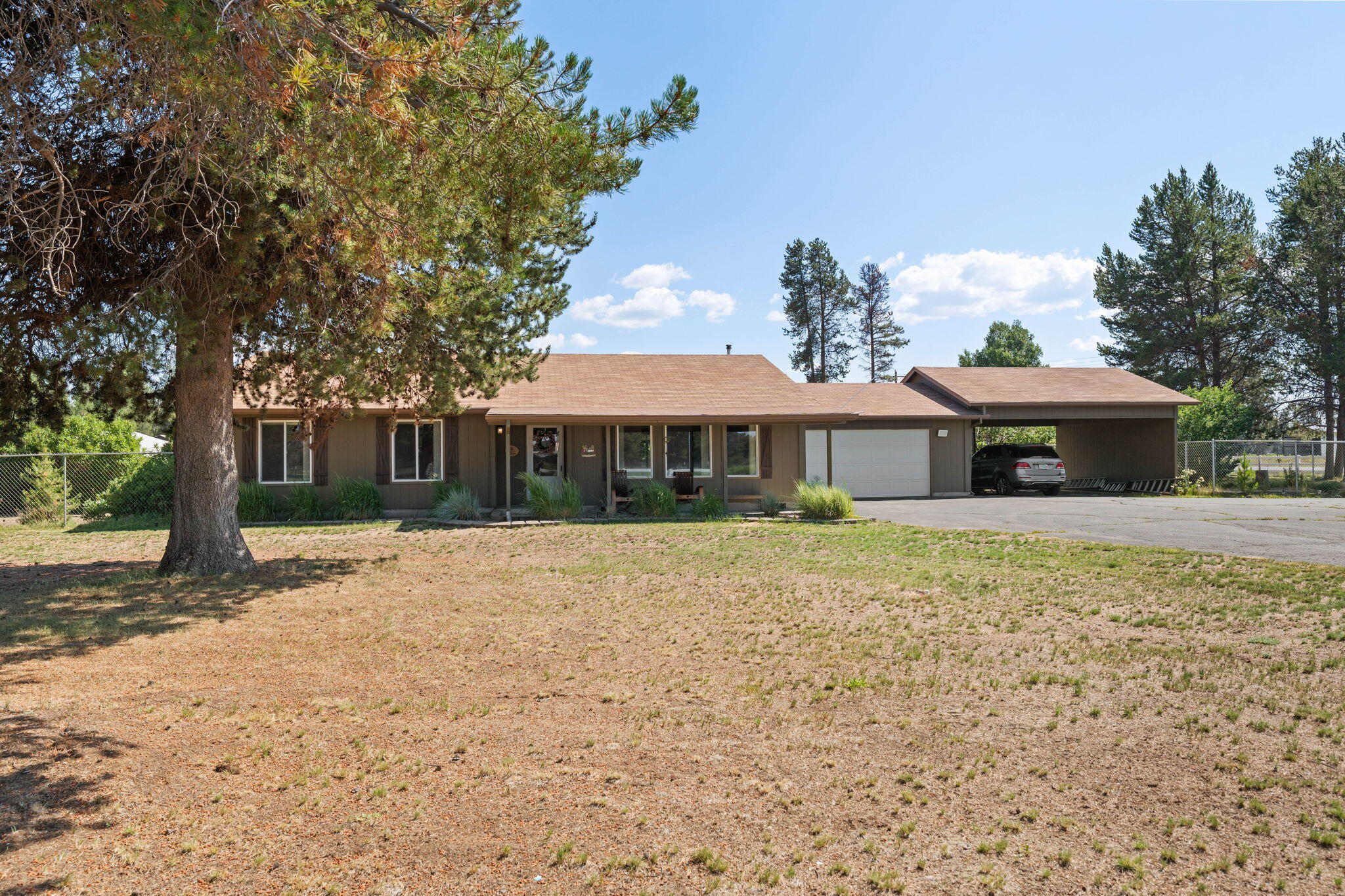 Cascade Mountain views on 2.61 acres in La Pine, Oregon! This 3 bed, 2 bath, 1,704 sq ft home offers privacy, functionality, and room to grow. The main house features a pellet stove, ductless heating/cooling, whole-house ducting, smart thermostat, and updated water heater (2024). Primary suite includes walk-in closet, ceiling fan, and tile shower. Kitchen has breakfast bar and includes 7-yr-old appliances. 2-car garage + attached 22x24 carport. Fully fenced backyard, covered front/back porches, water feature, raised beds, fire pit, and single level living. Outbuildings include: 31x31.5 hobby shop w/ bar + ductless, 48x25 greenhouse, barn, 3-bay carport, chicken coop, multiple gazebos (some w/ power), 13 frost-free hydrants, 2 wells (domestic + irrigation), garden shed, outdoor kitchen, and more. Two gated entrances and extensive storage. Move-in ready with space for homesteading, hobbies, or entertaining. Two gated entrances! So many possibilities and infrastructure galore!