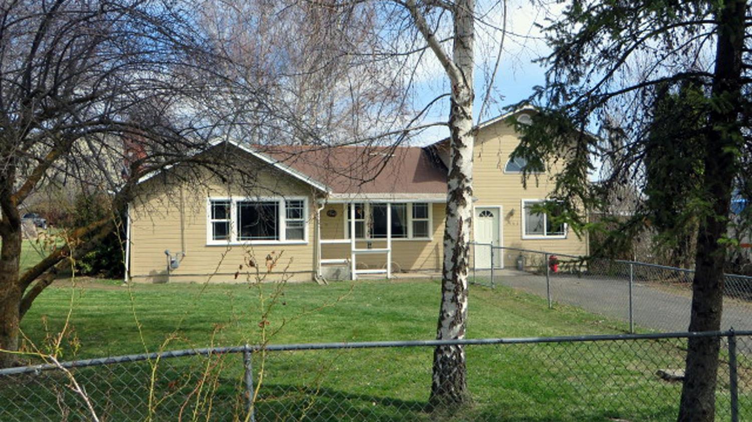 Nearly 1 acre with fenced pasture in the suburbs on a dead-end street. Beautifully updated 3 bedroom, 2 bath with over 1,700 sq ft of living area. Split bedroom floor plan. Bonus room has a loft and separate entrance, could be a 4th bedroom. Living room has fireplace with certified wood stove insert. Gas forced-air heat. Large side yard with second driveway and easy access to the back pasture. Seller will be installing a new composition roof before closing.