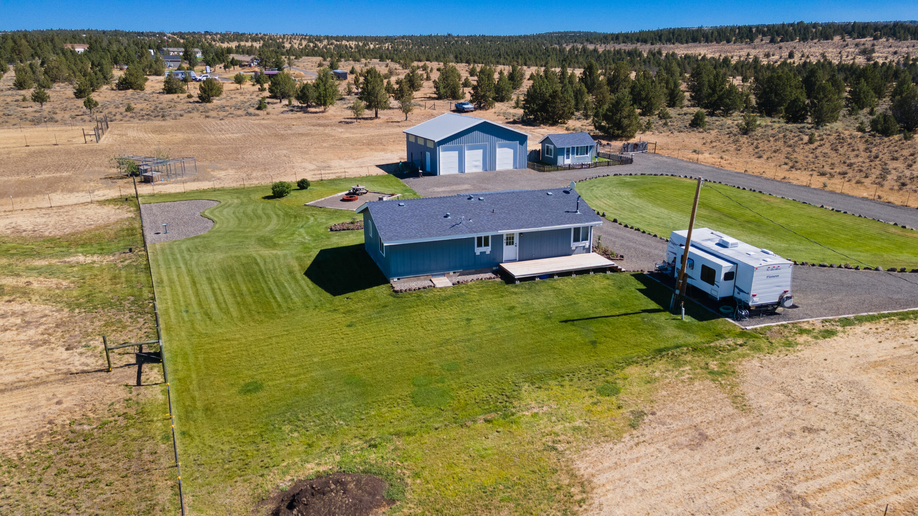 Enjoy peaceful country living with stunning mountain views in this 3 bedroom, 2 bath home on 5 fully fenced and cross fenced acres. The open floor plan offers a bright and inviting interior, perfect for relaxing or entertaining. The spacious kitchen flows into the living area, and the primary suite includes a private bath and walk in closet. Outside, you'll find a perfect RV parking spot with electricity and water hookups, a large shop for storage, hobbies or a home business, plus bordering state land - ideal for hiking, riding, or exploring. Whether you're looking for a full time residence or weekend retreat, this property has it all. Located in Ol&L, you are free from HOAs!
