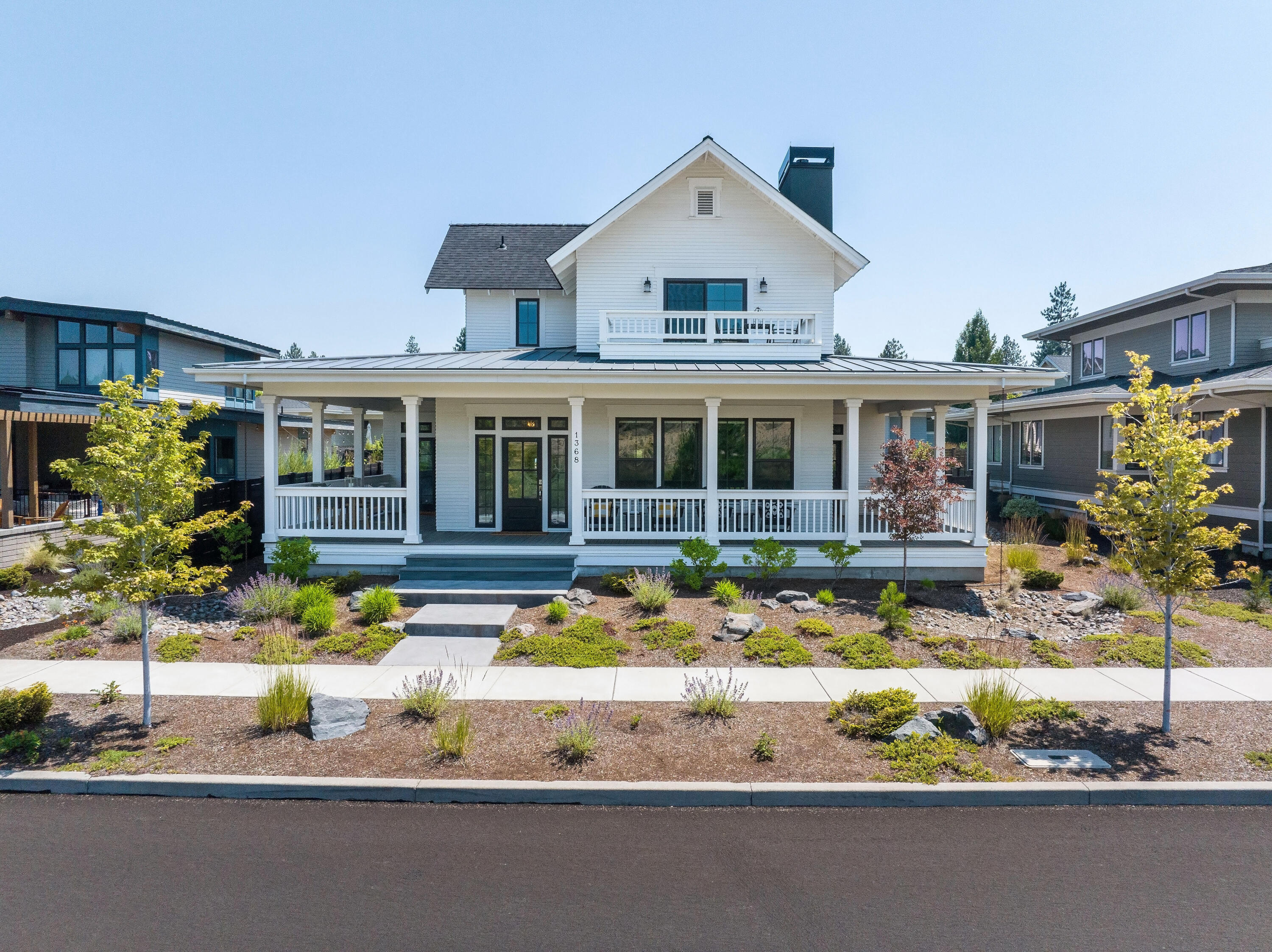 Located along one of NW Crossing's most desirable streets, this modern farmhouse captures serene Lakefront views of Discovery Park, paired with timeless neighborhood charm. The wraparound porch invites you to unwind & take in the scenery - striking in every season. Inside, high-end finishes meet comfort and style with a thoughtful layout, marble kitchen counters, custom cabinetry, stainless steel appliances, & seamless flow to the covered patio—the ideal atmosphere for year-round entertaining. The main level primary suite is the perfect retreat with park views, a spa-like ensuite & spacious walk-in closet. Rounding out the main floor, you'll find a bright office & laundry room. Upstairs, a spacious bonus room opens to a private patio with sweeping views, accompanied by two bedrooms & a full bath. With an attached two-car garage & close proximity to trails, top schools, shops, & the farmers market—this is Bend living at its finest.