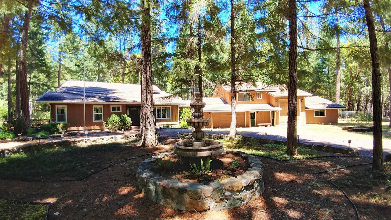 Gorgeous property with a quality custom home, a serene and private 5 acre forest setting with beautiful grounds, a fabulous water feature with creek and waterfall and fiber optic Internet installed to house, all within an easy 20 minute drive to Grants Pass. The home itself is stunning, with three vaulted wood ceilings, two Montana river rock fireplaces, including one that soars up two stories, and woodwork throughout. The home has two master suites, a charming custom kitchen and a formal dining room/office. The open loft with circular chairlift (chairlift stays with home) offers a spectacular view of the two story windows in the living room. The two bedrooms and living room have doors opening to extensive decking which let in the soothing sounds of the waterfall. A 1 bedroom guest apartment (480 sq ft), a garage with 1/2 bath, RV garage and converted workshop with ductless heating and air, additional RV hookups, hot tub and partial fencing all complete this exquisite home.