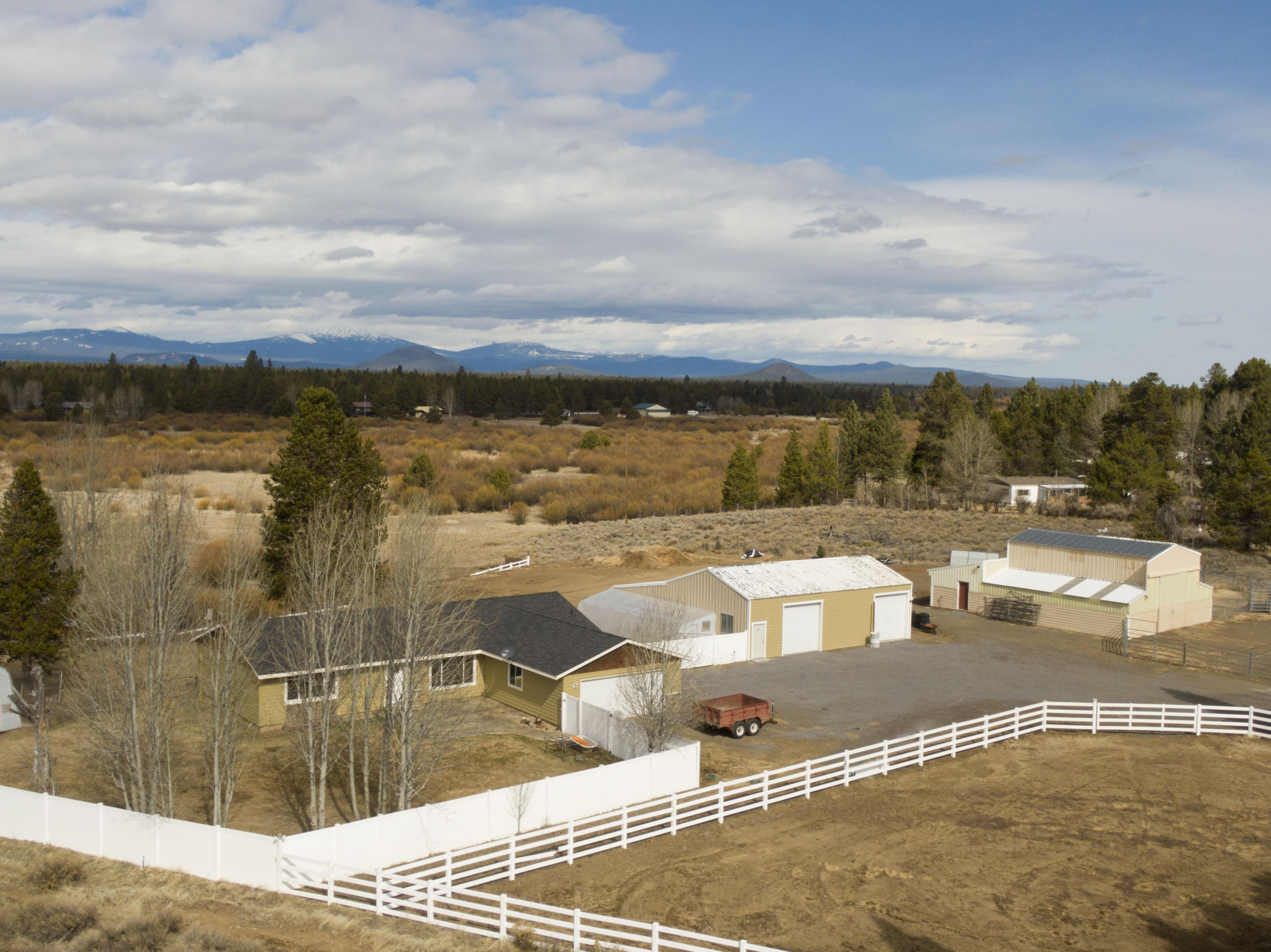 10.36 acres of picturesque horse property w/ views of the river & Cascades as the backdrop. Updated farmhouse w/ a gourmet kitchen & large windows in the main living area is perfect for entertaining. Kitchen ftrs dining area w/ large central island, granite counters, double oven, gas range w/ pot filler, full height designer backsplash & soap stone farm sink. Main living area is newly carpeted & right off kitchen w/ built-in entertainment area. Primary bedroom ftrs a tiled walk in shower, walk in closet. Two guest bedrooms share an updated walk-in tiled shower as well. Oversize laundry area w/ built ins & a sink, bonus room & half bath off entry. Property boasts a 5 stall barn, black sand arena, insulated tack room, & hay loft. Two in ground greenhouses w/ power & water for an extended growing season. A large shop, 400 amp power. Fish, kayak, swim or float in the Little Deschutes River in the summer. Horse trails nearby & close to skiing/snowmobile parks. High speed internet & no CCRs.