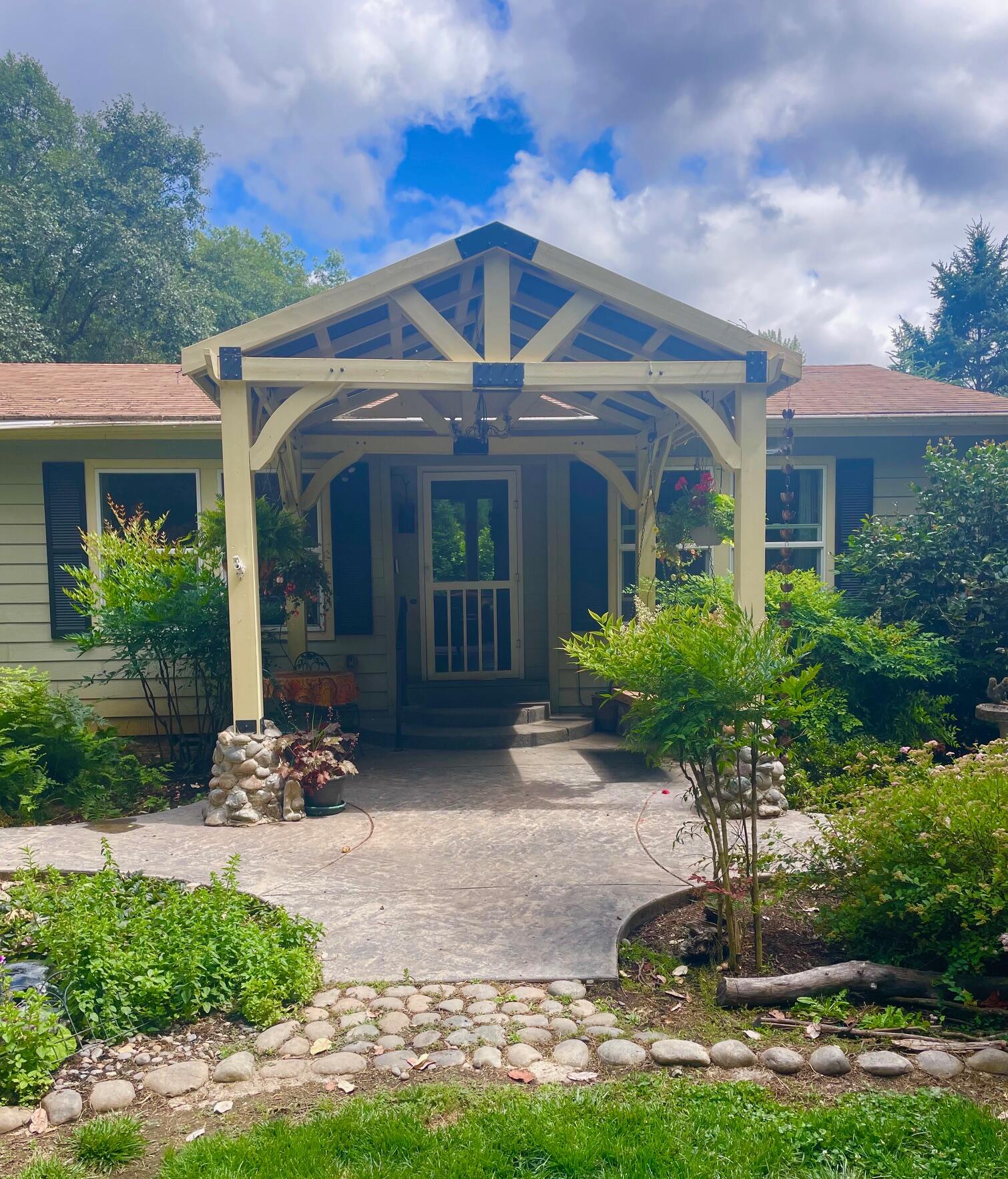 The sweetest little homestead on Pass Creek.  Enjoy solitude of sitting areas overlooking creek, enjoying sights and sounds and smells of gardens including water features.   Fenced vegetable garden includes, berries, plum, pear, apple and peach trees.   
Large deck with pergola for gathering.  Multiple fenced pens, barn and hay barn.  New roof coming July 7.  Fireplace is propane in family room and this craft area also has sink and microwave.    Sellers needs to locate replacement home.