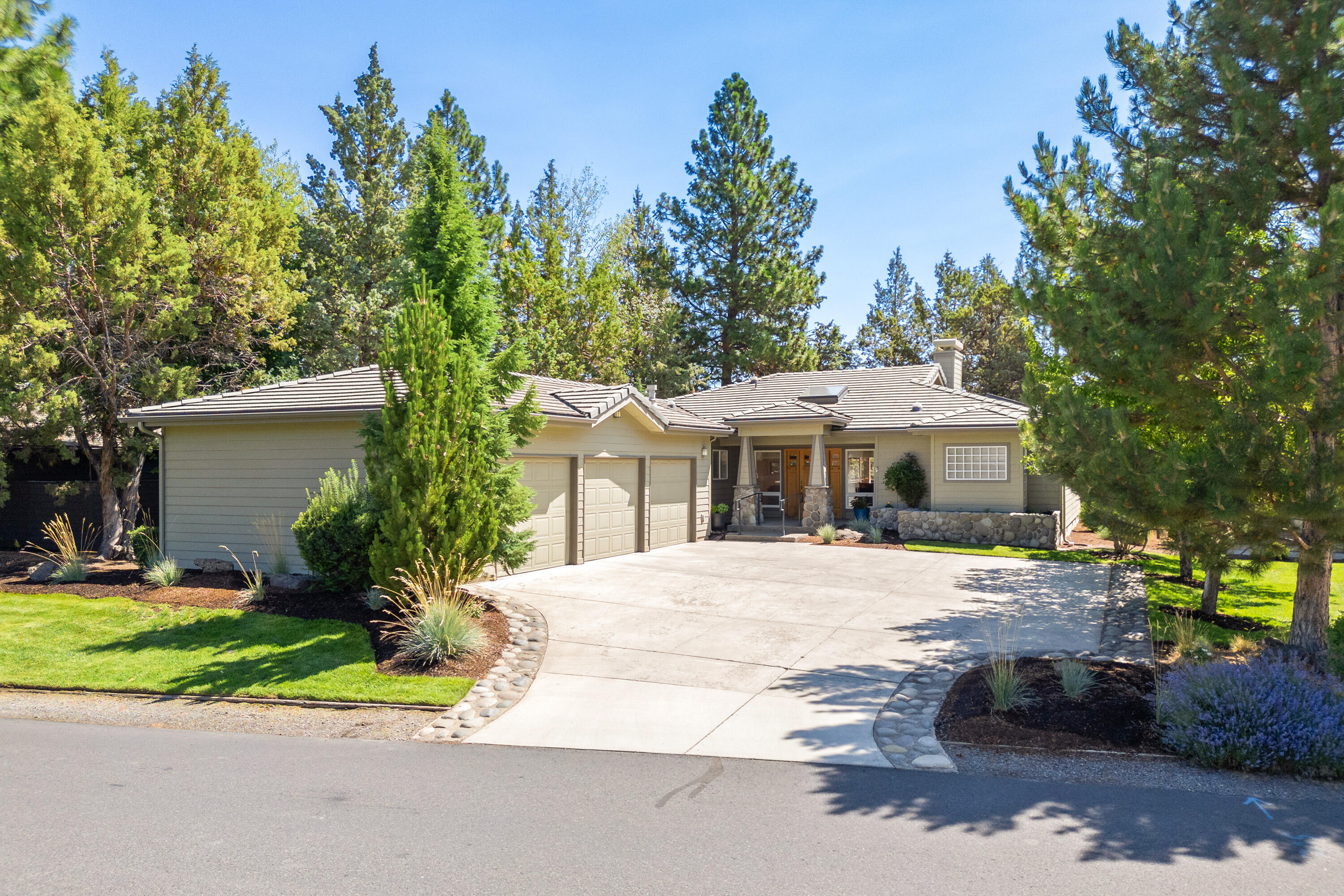 Enjoy single-level living and gorgeous natural light in this charming Bend home! Nestled in a quiet gated neighborhood on Bend's west side and backing to the 5th hole of River's Edge Golf Course, the location offers easy access to trails, parks, restaurants, and the Deschutes River. This home features a three-car garage, tile roof, two fireplaces, central A/C, and a beautifully remodeled primary bath. The HOA takes care of front yard landscaping, snow removal, and trail maintenance, making life a little easier. Inside, you'll find wide plank hardwood floors, vaulted wood ceilings, skylights, and a hidden office tucked behind a bookshelf. The spacious back deck lives like a second living room, with peaceful views of mature trees and the fairway. With a layout that feels both open and cozy, this home offers comfort, style, and convenience.