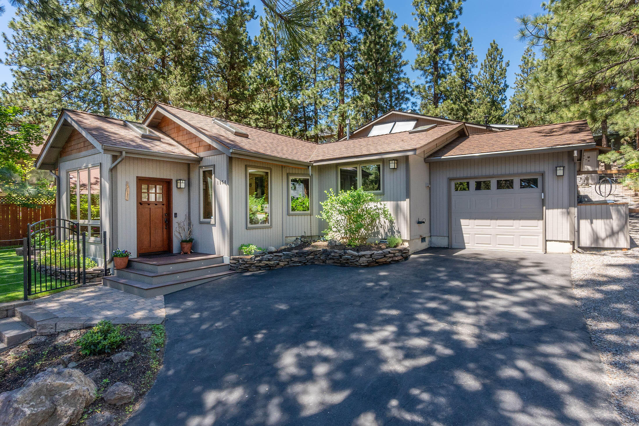 With gracious mature Ponderosa Pines framing this home with skylights everywhere you turn, there is a feeling of living in a secluded treehouse in the heart of Bend's west side, yet just a hop away from popular restaurants and shopping on Century and 20 minutes from Mt Bachelor.  Escape through the front door into a bright and cheerful room with multiple windows, 4 skylights and radiant concrete floors. Enjoy the open floor concept with updated spaces including the kitchen and bathrooms.  The one car attached garage is complimented by a large detached garage, fit to store your RV and all your Bend-living toys. A uniquely landscaped side yard features a gas hookup for your grill, a concrete a pad/wiring for a hot tub, and multiple spaces for relaxing or entertaining. Storage is not lacking with built-ins throughout, a large mud room, as well as overhead and shelved storage in the garage.