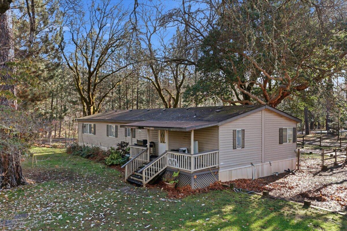 An extremely rare Rogue River waterfront offering a gentle walk to the water and beautiful river views throughout the property. This 2.74 acre parcel offers exceptional versatility and can be purchased on its own or together with the neighboring estate at 1407 Upper River Rd. The property includes a financeable double wide manufactured home, along with outstanding shop and studio space. Improvements include an approximately 800 square foot newly built detached garage/shop, an additional approximately 800 square foot detached garage with an art studio featuring windows overlooking the Rogue River, and a large approximately 1800 square foot metal shop ideal for storage, hobbies, or business use. A peaceful river setting, rare usability, and flexible purchase options make this a truly special opportunity along one of Southern Oregon's most desirable stretches of the Rogue River.