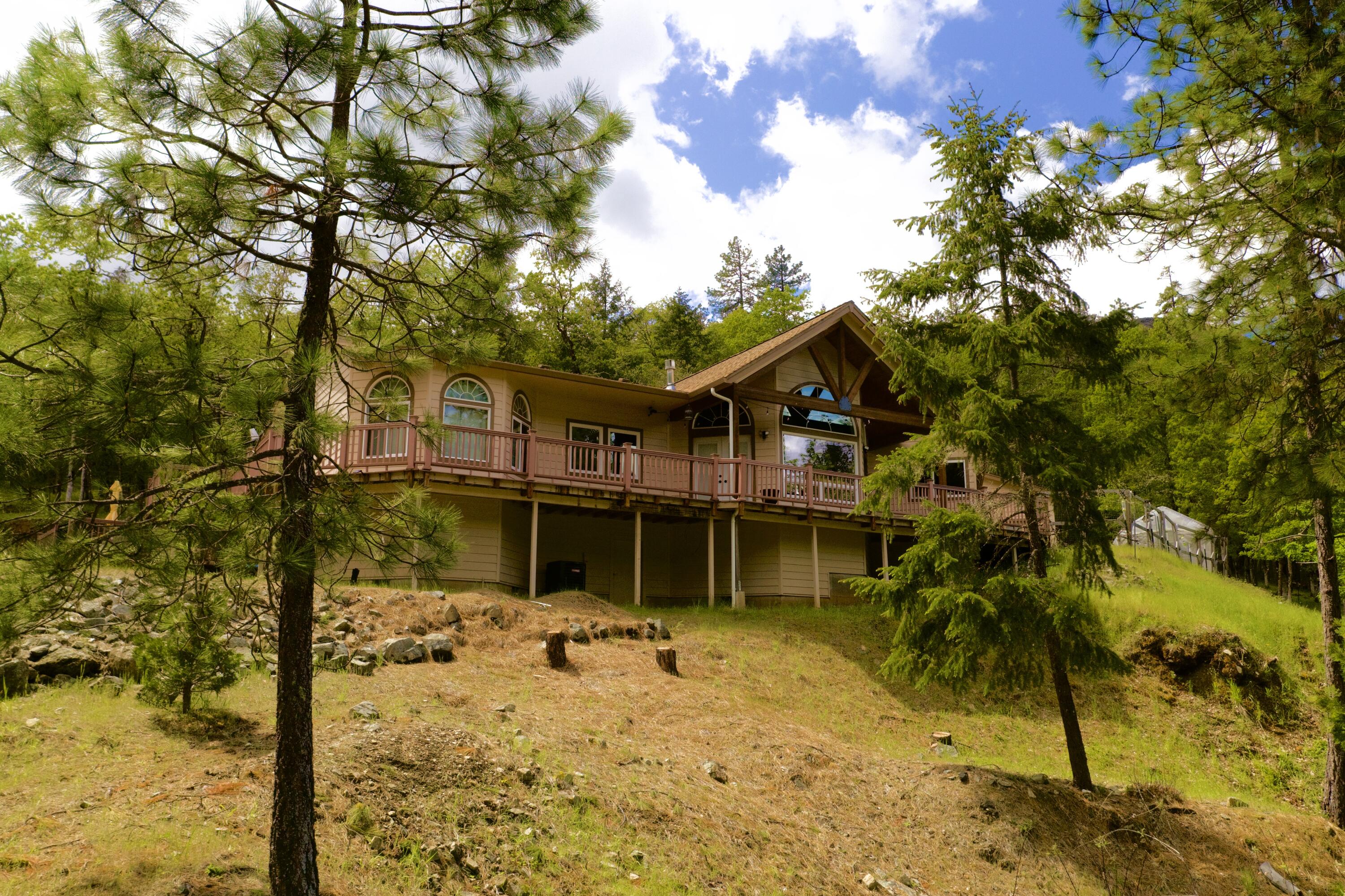 Looking for private acreage complete w/ Creek frontage & back up to hundreds of acres of accessible BLM? This is it!
Inside this custom home you will be greeted by a stunning living room featuring hardwood floors, vaulted pine ceiling, exposed beams & French doors all leading out onto a wraparound deck w/ valley views.  Home features include sizable kitchen w/ huge walk-in pantry, library nook, solar water heater, new mini splits, 3 bedrooms, 2 full bathrooms & bonus room that would make the perfect office, craft room or... Handicap accessible w/ extra wide hallways & walk-in shower located in the primary on-suite bathroom.  Home sits above on a terraced lot & below there is a large flat area w/ plenty of parking for all your vehicles and toys.  Attached 2 car garage above & below has RV hook-ups, huge fully insulated 1,200 sq ft shop w/ attached 360 sq ft room that is perfect for any hobbyist.  Various hardwoods & room to garden!  A true Oregon Dream!
