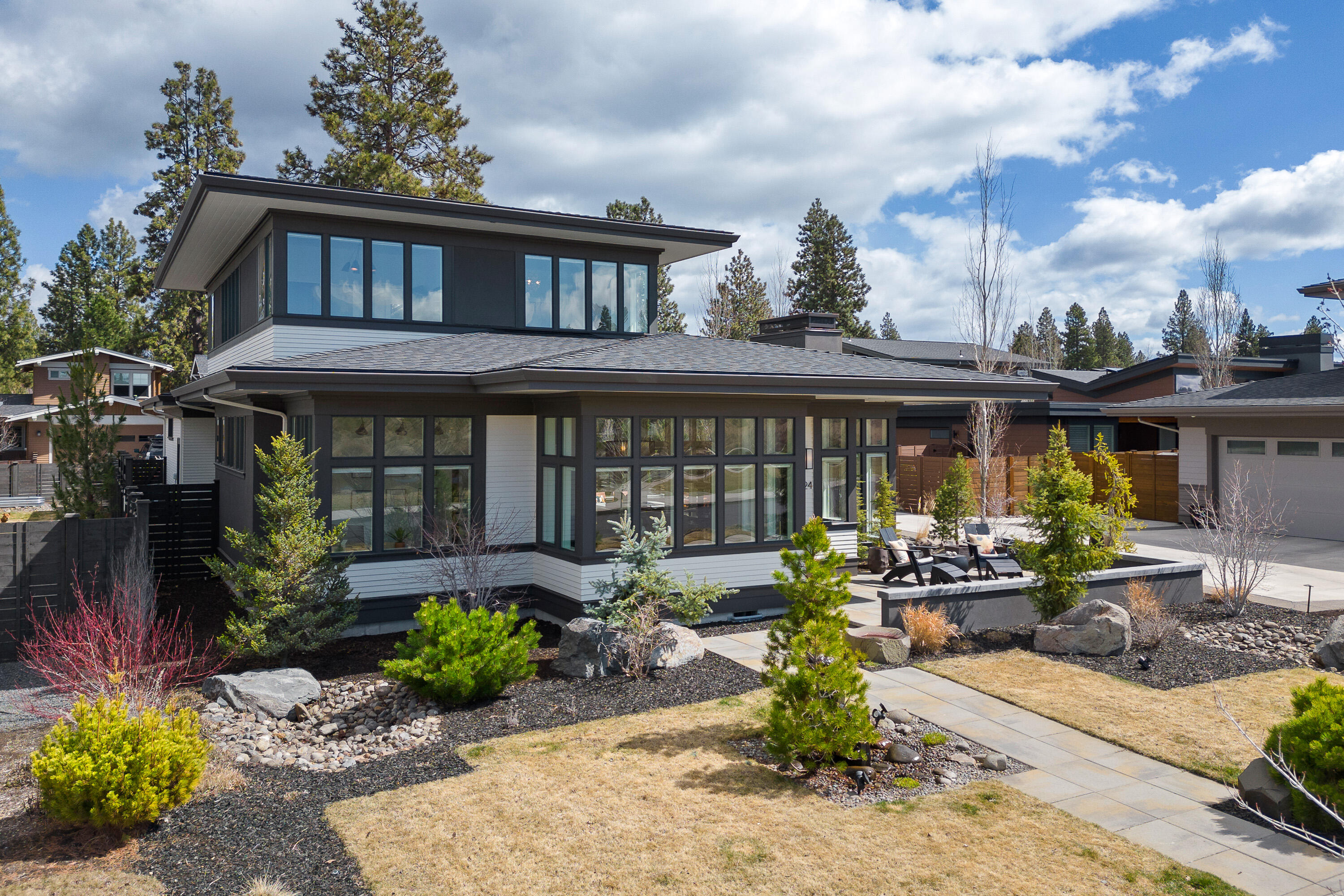 Experience luxury living across from Discovery Park in this award-winning prairie-style home that defines Northwest Crossing living. Featuring walnut herringbone floors and abundant natural light, every corner radiates warmth and elegance. Fine hardwoods, solid-surface countertops, custom cabinets, and designer lighting adorn the home. A custom floor plan designed and built by Salvesen Homes boasts a chef's kitchen, office, primary suite, and a chic powder room on the main level. Upstairs, a bright spacious loft with two bedrooms, built-ins, and a full bathroom awaits. Expand your space outdoors with a large patio, firepit, and meticulously landscaped yard offering stunning views. Enjoy gentle sunrises to the east and dramatic sunsets over Mt Bachelor to the west. The three-car garage, with unique breezeway, adds practicality and charm. Experience the epitome of Northwest Crossing living in the spectacular, one-of-a-kind home.