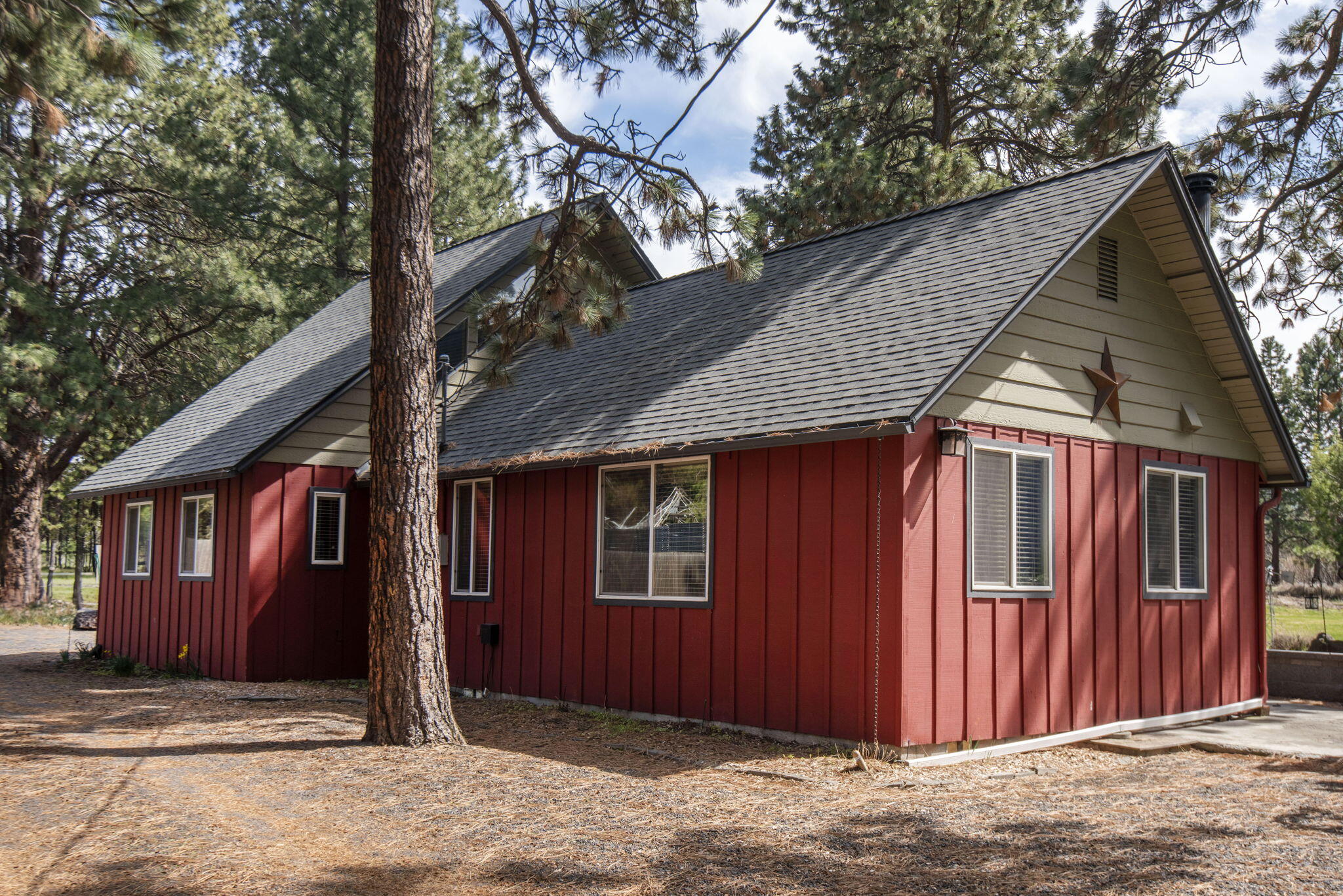 A level and landscaped 1.77 acres of picturesque property in Deschutes Riverwoods complete with 1 acre of deeded irrigation rights and a 2,000-gallon cistern. The grounds are park-like, with a large, beautifully maintained lawn, a water feature flowing into a pond, and visits from local ducks and geese. Mature Ponderosa Pines add to the setting. The 3-bed, 2-bath home has been updated over time, including engineered hardwood floors, modern appliances, and a vaulted primary suite upstairs with its own private deck and walk-in closet. The living room features an efficient wood stove. For storage and projects, there's a 36x42 steel pole building with a 14-foot roll-up door, two 220v outlets, RV hookups. Large, 220v air compressor, plumbed in shop. A separate 20x26 garage with workshop space. Fully fenced, gated, and irrigated with an 8-zone system.