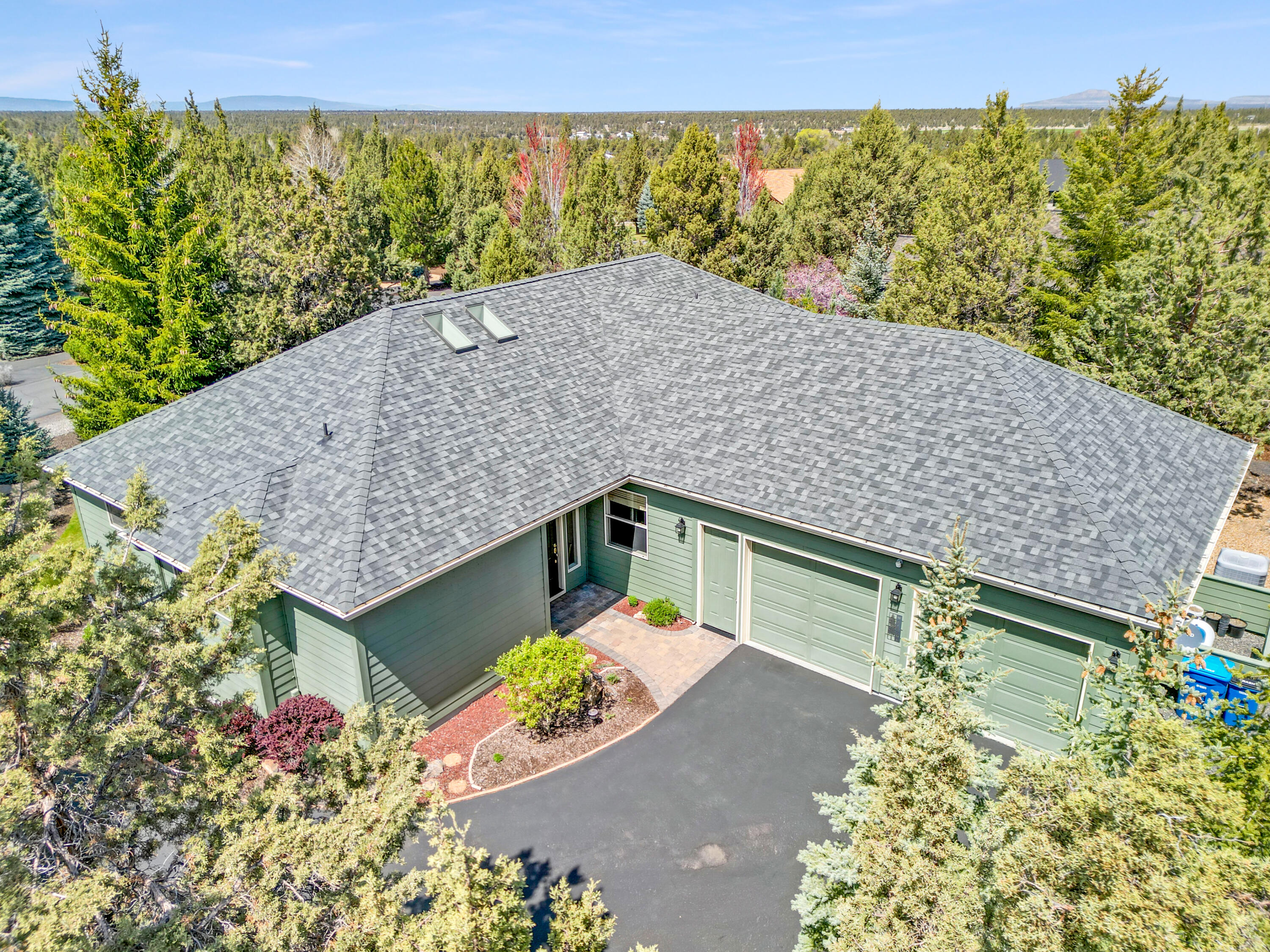 This spacious Eagle Crest home is thoughtfully designed with two en-suite bedrooms, a third bedroom/office, and a third full bathroom with jetted tub. Abundant windows allow the open floor plan to glow with natural light and draw in the quiet enclosure of mature trees and native plants surrounding the home. Designer touches include solid hickory flooring, quartz counters, and a capacious kitchen with peninsula seating and cook's workspace. Practical features include a wealth of storage, newer HVAC with allergy filtration, a generous laundry/craft room with 2 sinks, and an oversized garage with built-in cabinets and workbench. Outside you'll find Trex decking, paver patio, retractable shade awning, raised garden beds, low maintenance natural landscaping with gravel paths, and lots of privacy and tranquility. Enjoy EC golf courses; indoor and outdoor pools, pickleball, and tennis; sports centers and spa; and miles of trails.